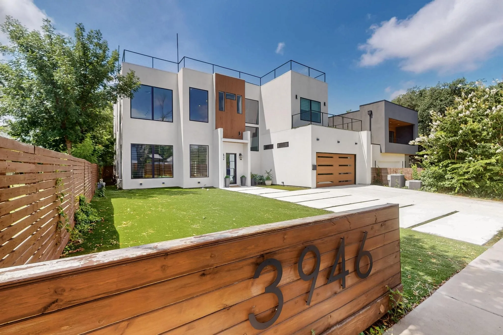 Contemporary architectural design featuring a white stucco exterior with contrasting wood-look accents
