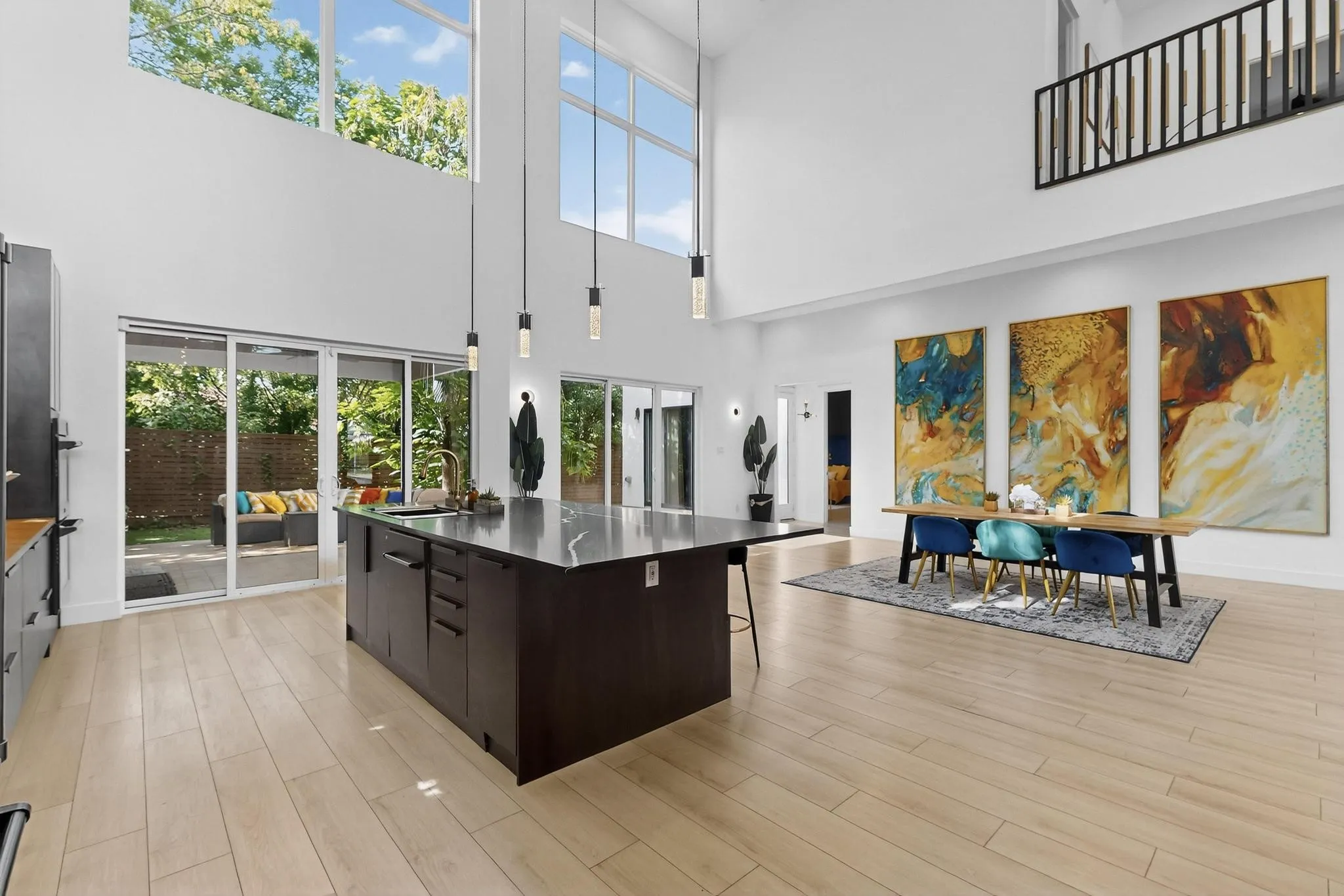 Open-concept interior featuring high ceilings, wood-finish flooring, and multiple sliding glass doors