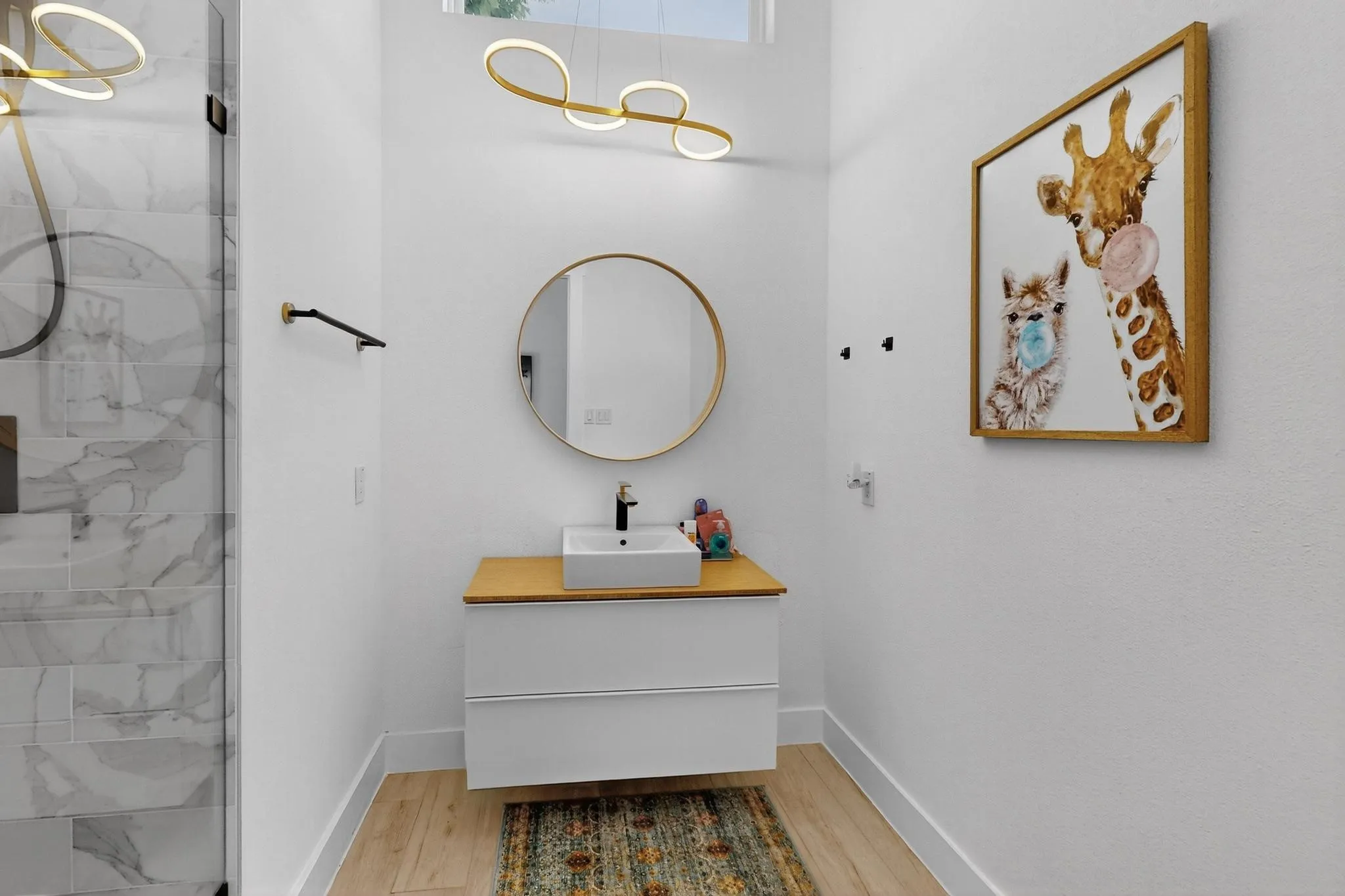 Modern bathroom featuring a floating vanity with a wood-finish countertop and vessel sink