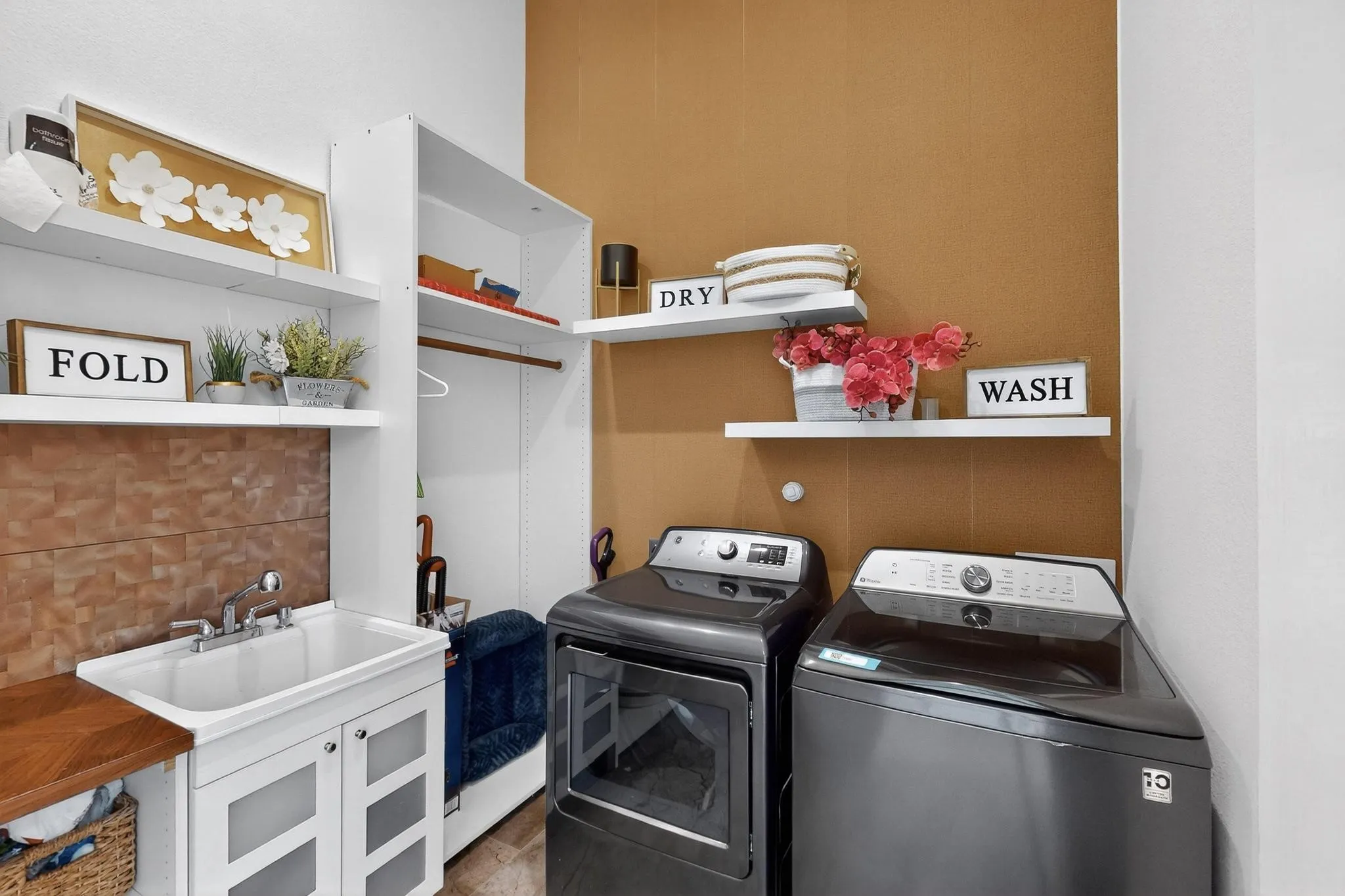 Dedicated laundry area featuring a utility sink with a wood-finish countertop