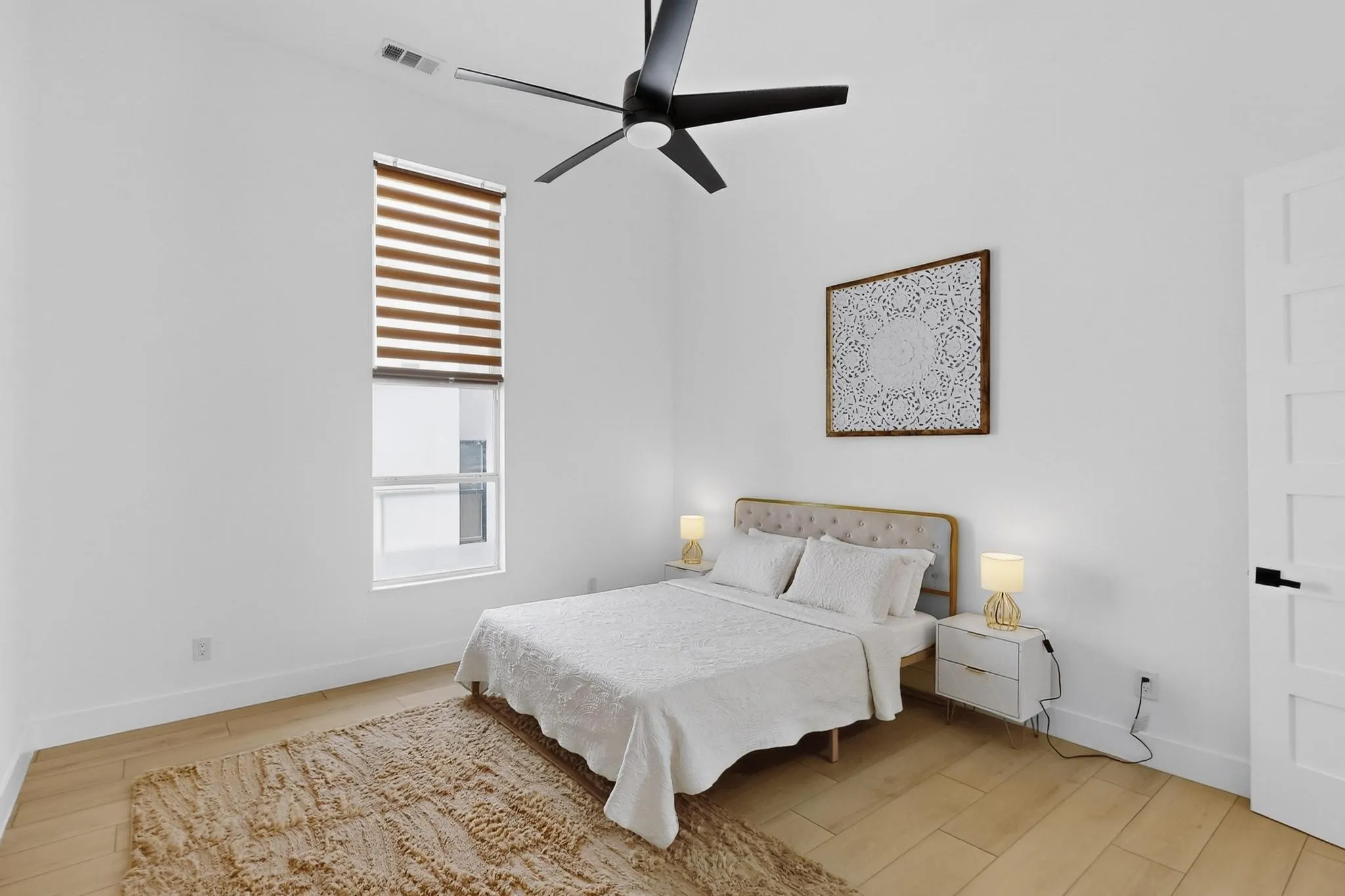 Room featuring a vaulted ceiling with a modern ceiling fan, wood-finish flooring, and a tall window with horizontal blinds