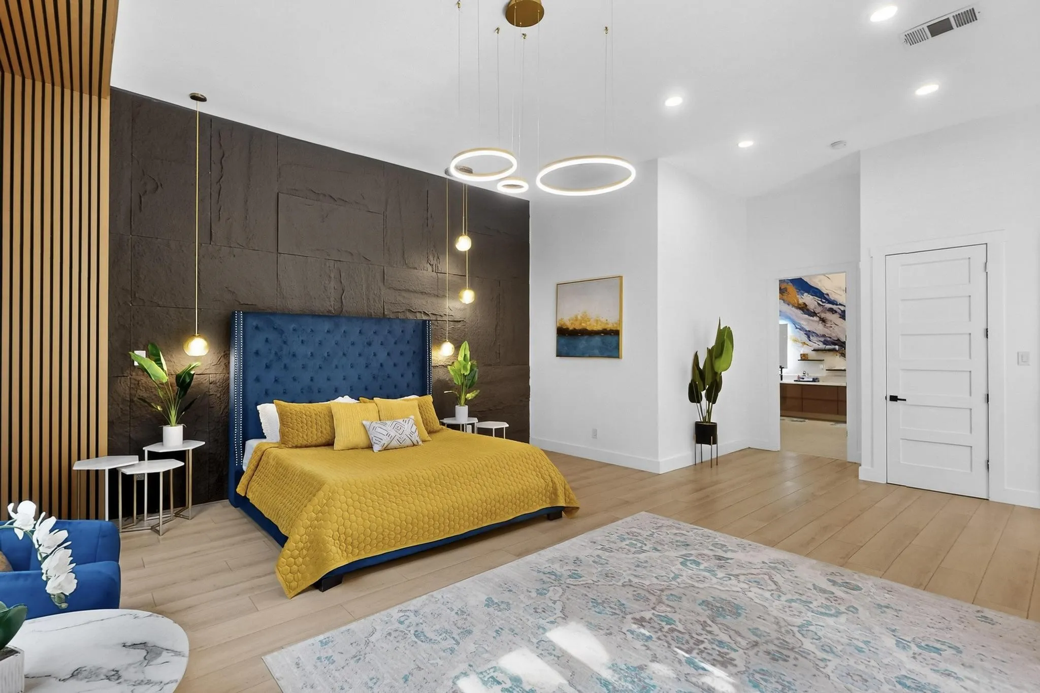 High ceilings complement a feature wall with natural wood slats and textured dark panels