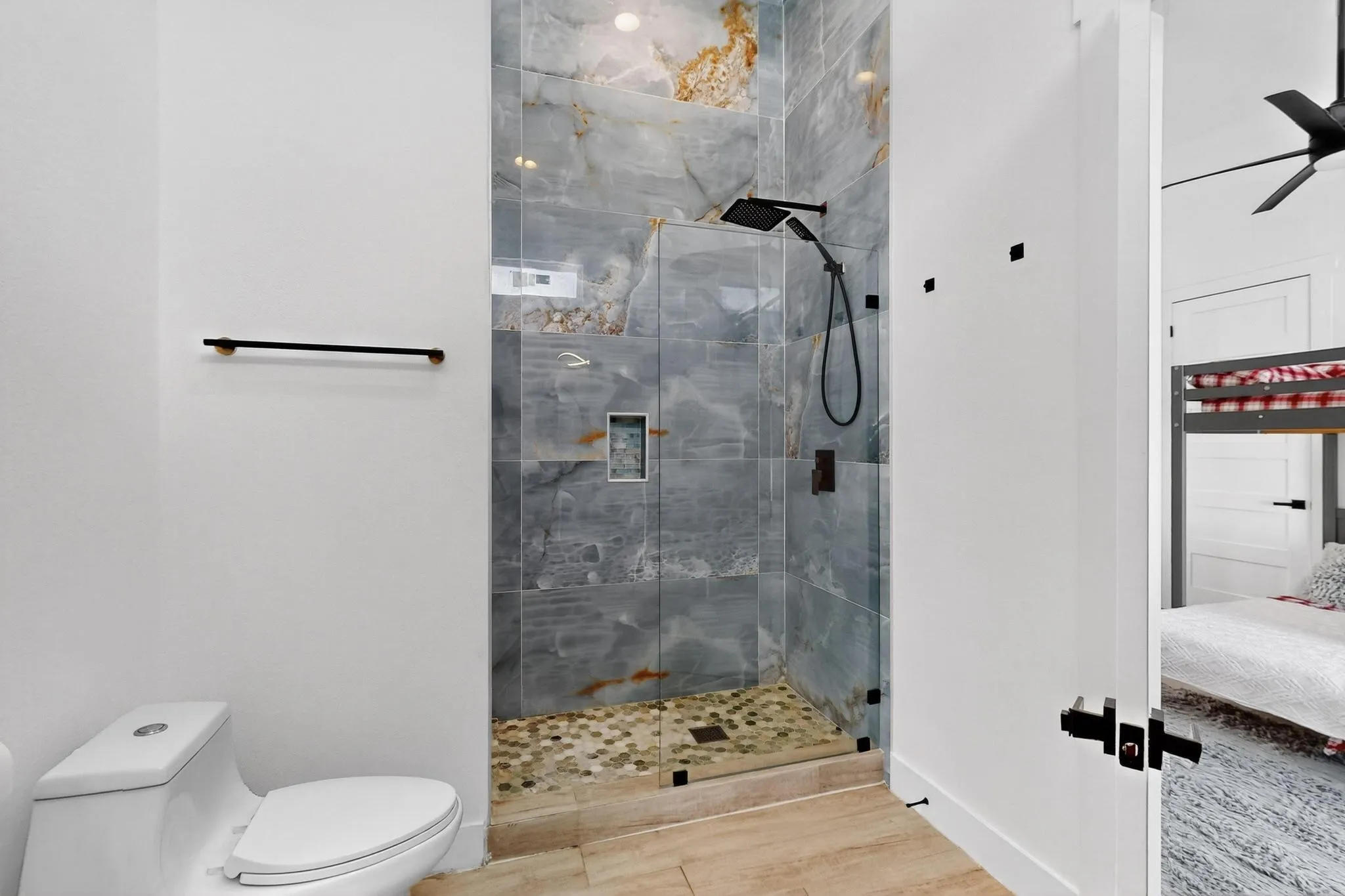 Contemporary bathroom featuring a spacious glass-enclosed shower with large format wall tiles and a pebble floor
