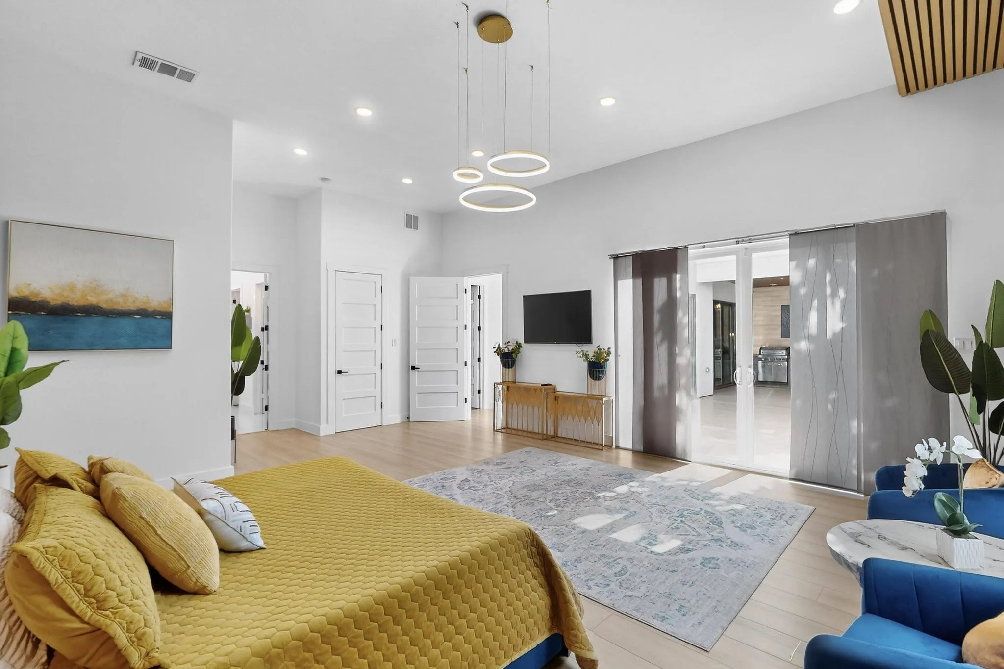 Spacious room featuring light wood-finish flooring, recessed lighting, and a modern chandelier