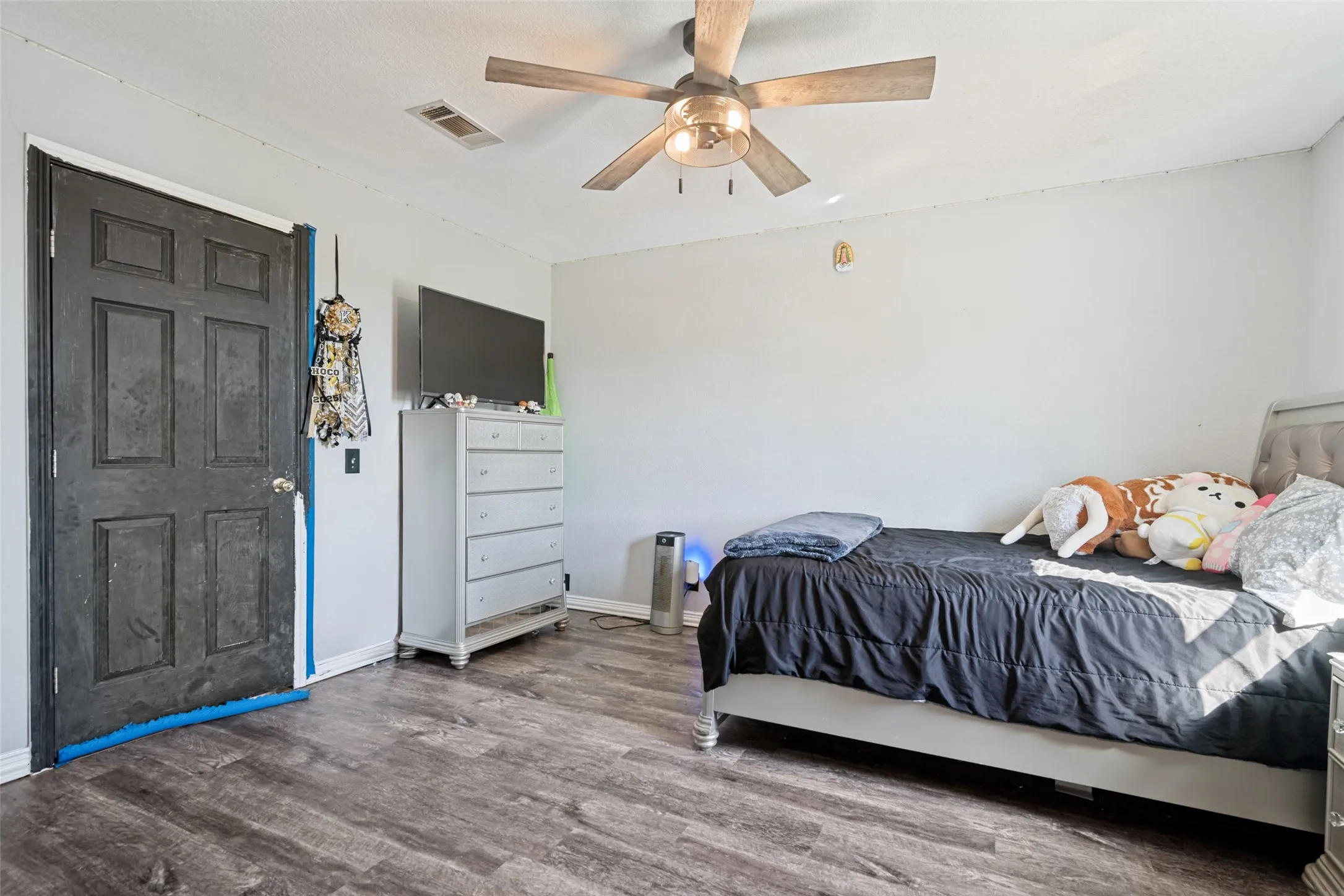 Interior room featuring wood-finish flooring, a ceiling fan with integrated lighting, and light-toned walls