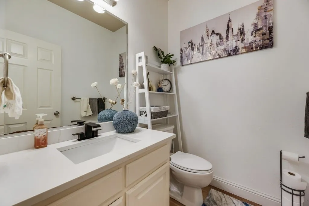 White vanity with an integrated rectangular sink, matte black faucet, and a large mirror