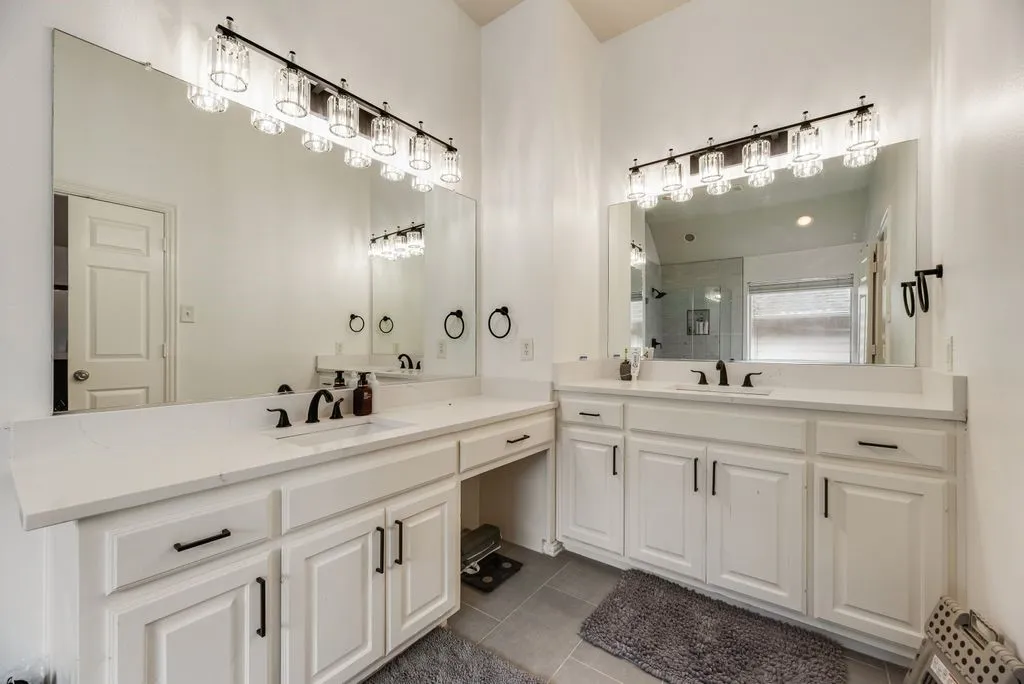 Dual vanity with white cabinetry and integrated sinks, complemented by matte black fixtures and hardware