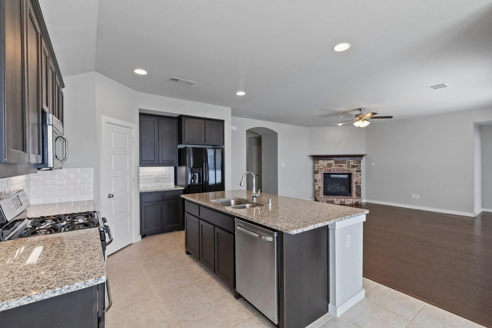 Kitchen featuring dark cabinetry, granite countertops, and tile flooring