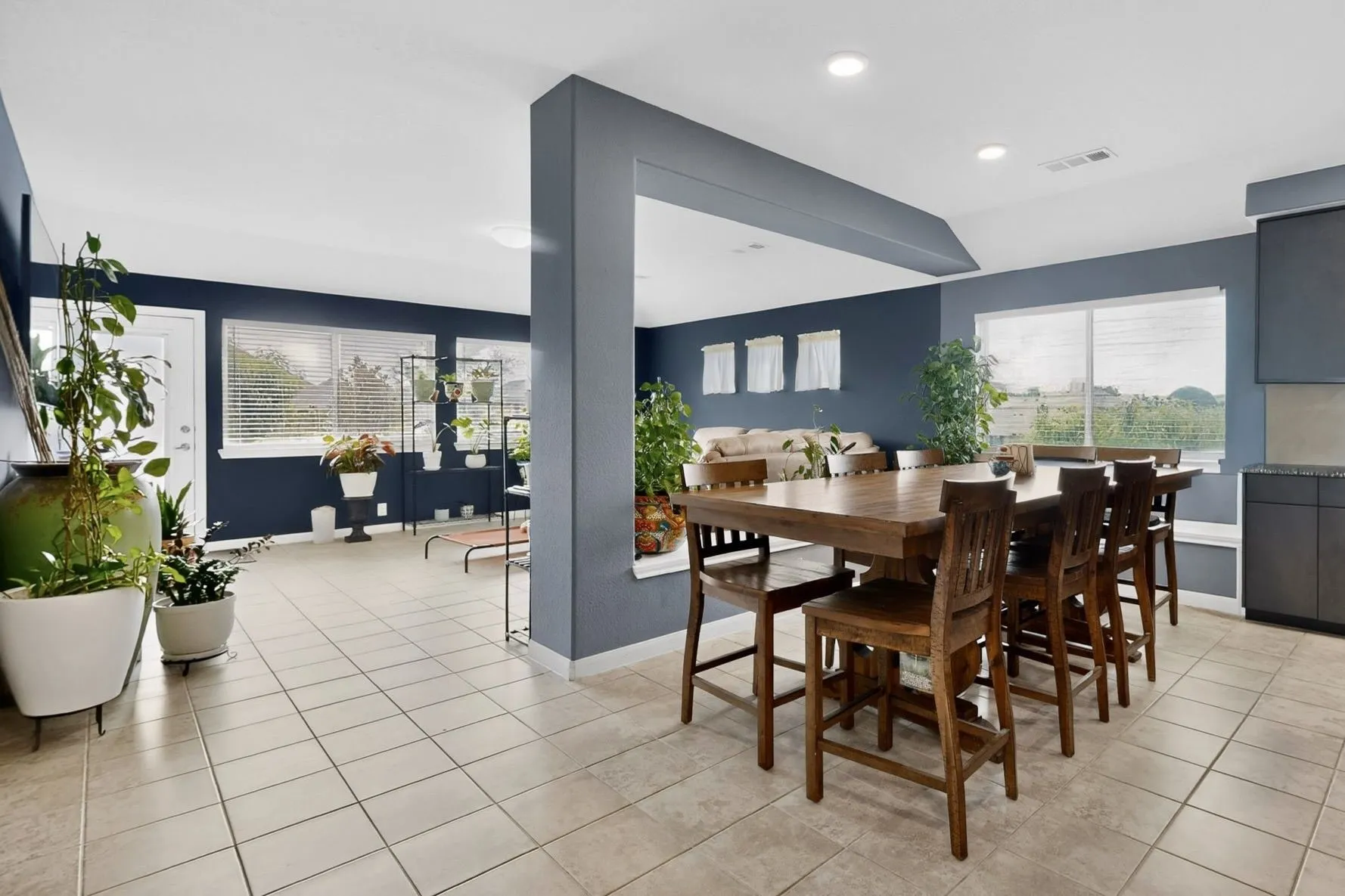 Open-concept living space featuring tile flooring, recessed lighting, and multiple windows with blinds