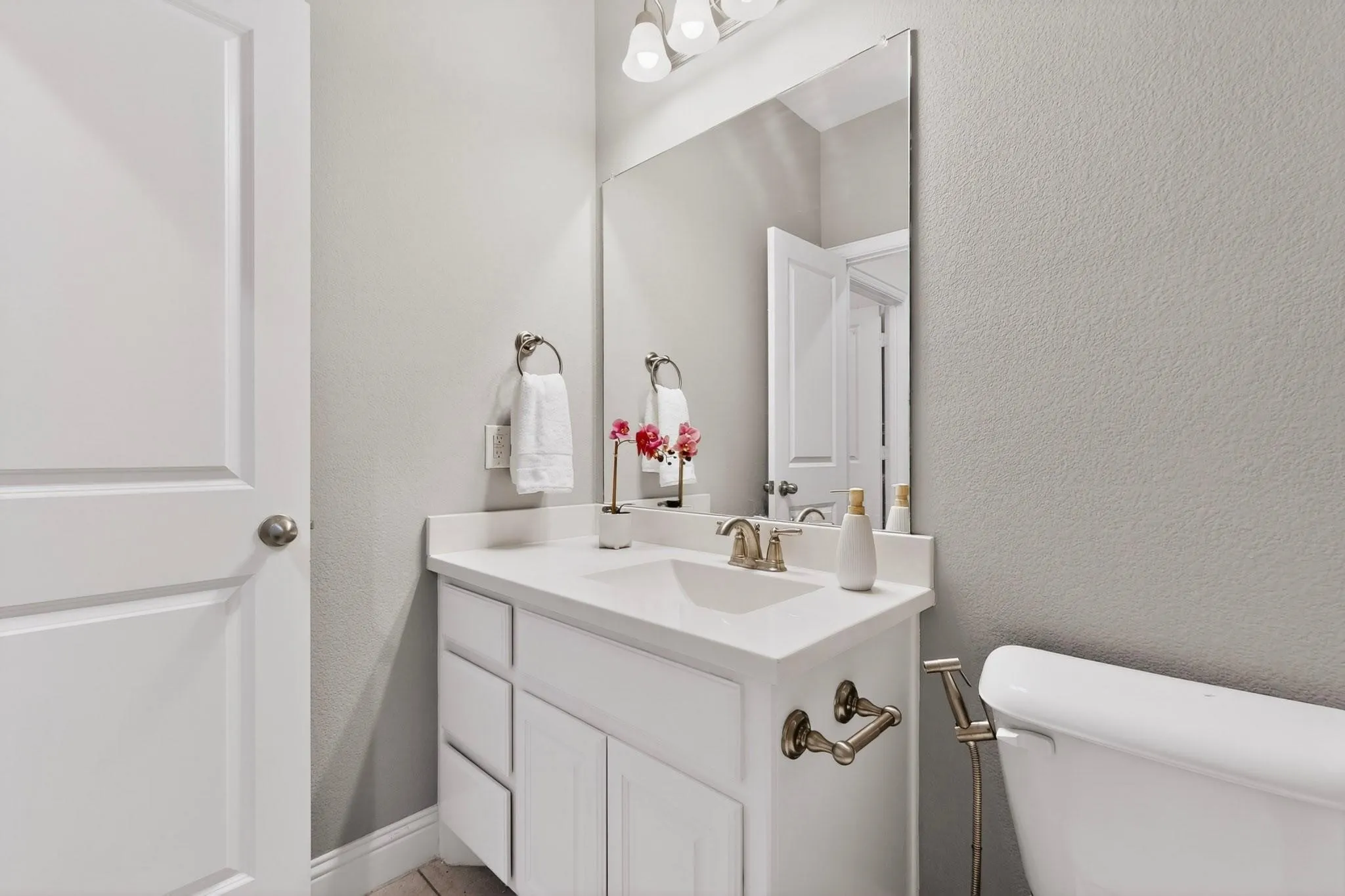 A clean bathroom featuring a toilet with bidet and vanity