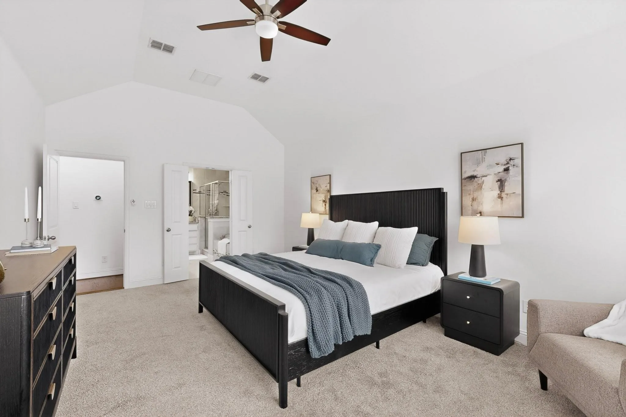 A spacious primary bedroom featuring a ceiling fan and an en suite bath.