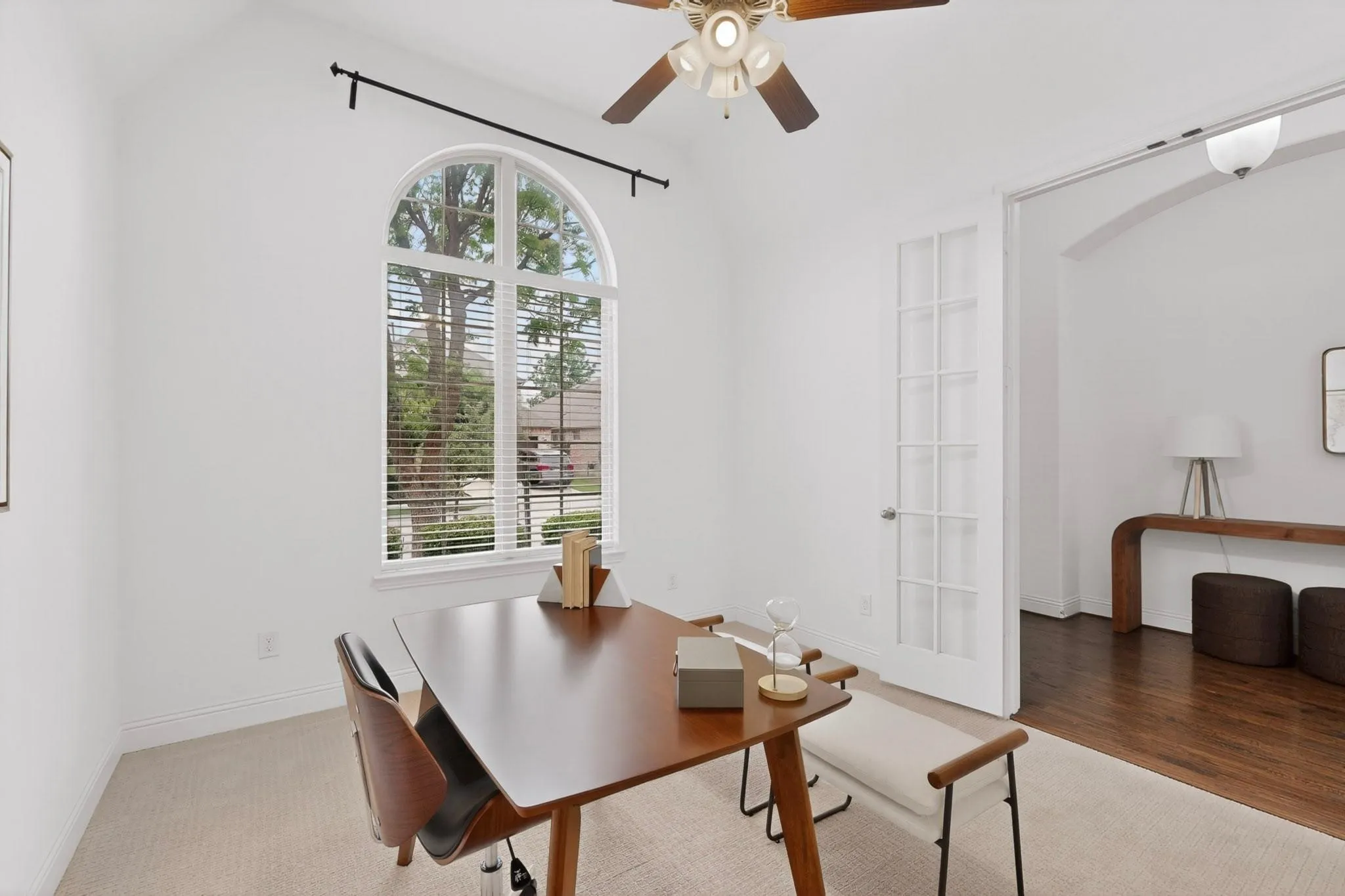 Bright office with a ceiling fan and a tall window overlooking the front yard