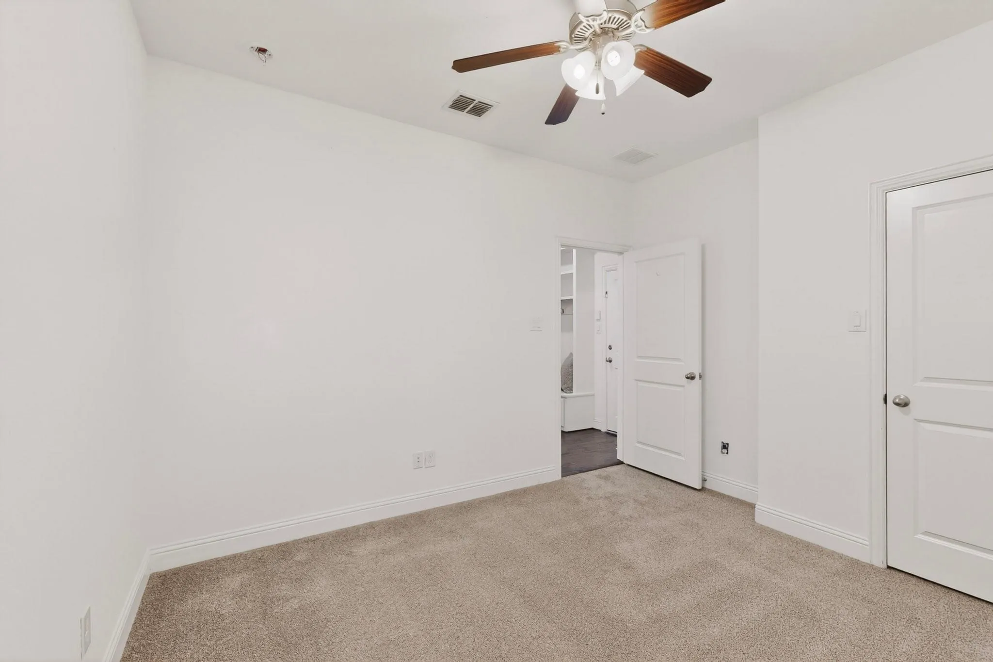 A bright bedroom featuring a ceiling fan and a walk-in closet