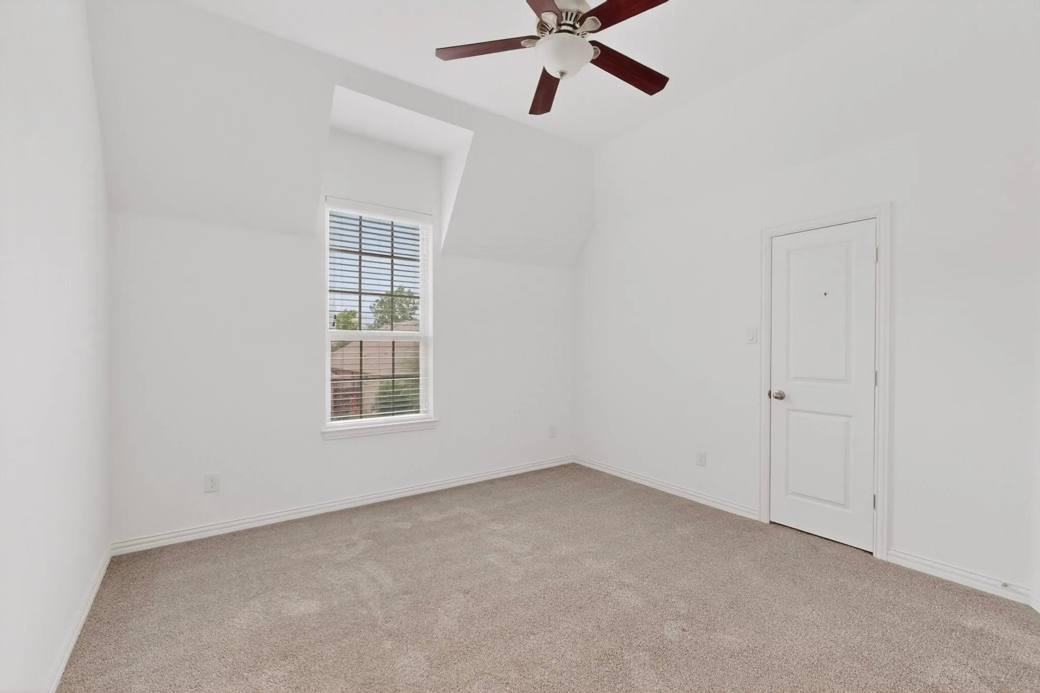 A bright bedroom featuring a ceiling fan and a window