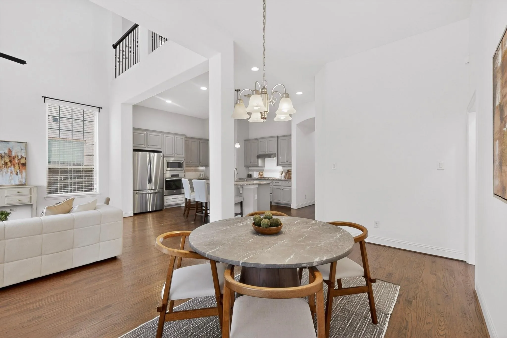 Spacious dining area showcasing elegant hardwood floors and a chandelier, blending style and comfort for everyday living.