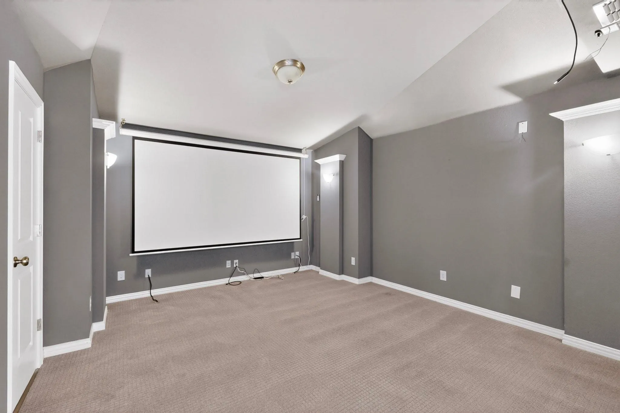 A stylish home theater setup with a projector screen, perfect for enjoying films.