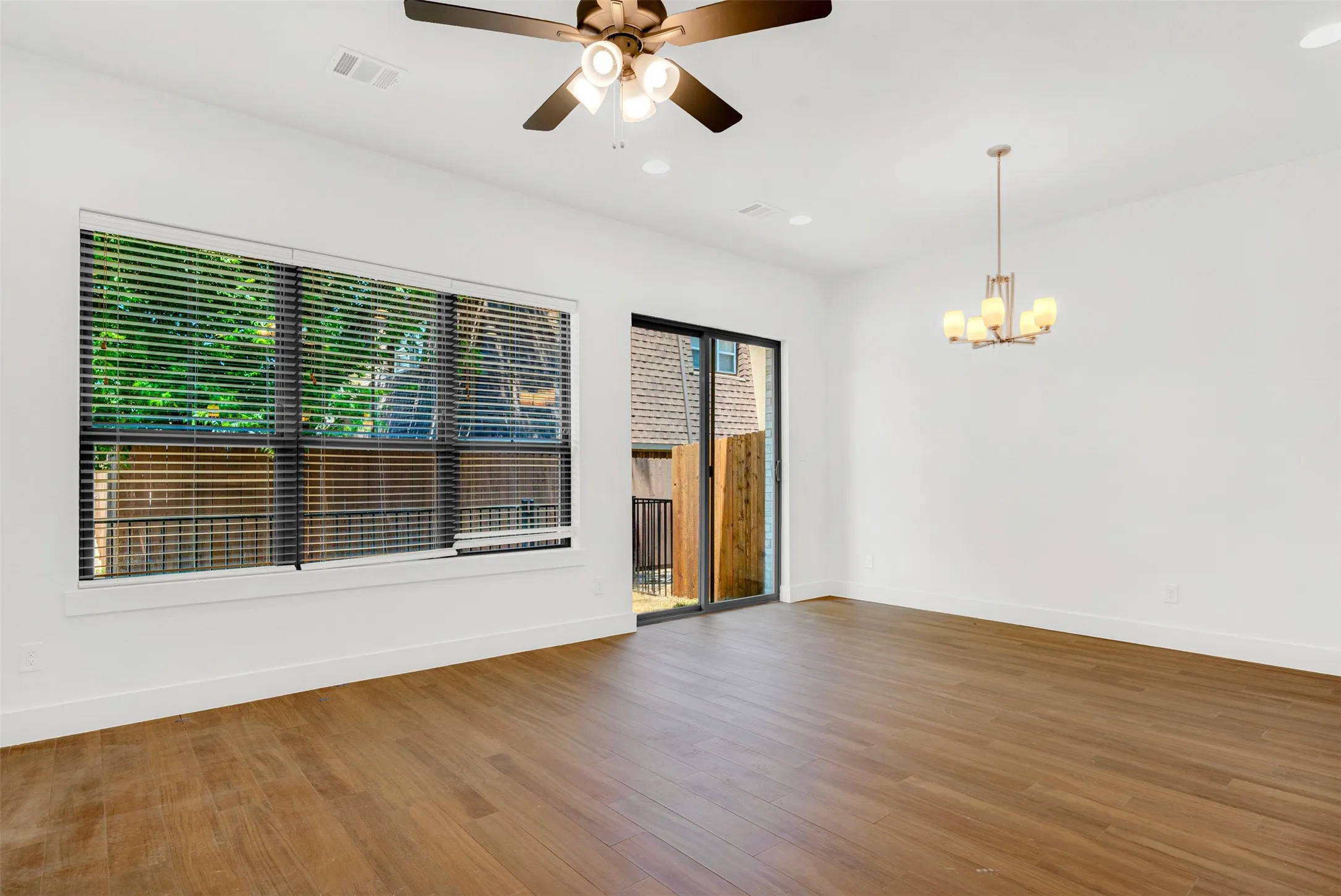Spacious open-concept living and dining area with luxury vinyl flooring. Patio doors open to small fenced patio.Thick door/curtain covering