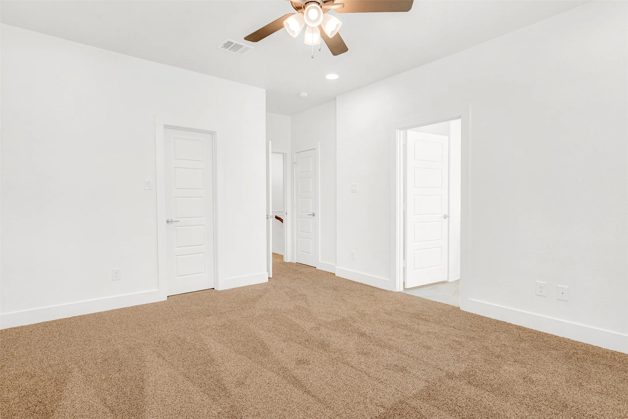 Large master bedroom and door on the right leads to spa-like master  bathroom.  Door to the left leads into spacious his and hers closet