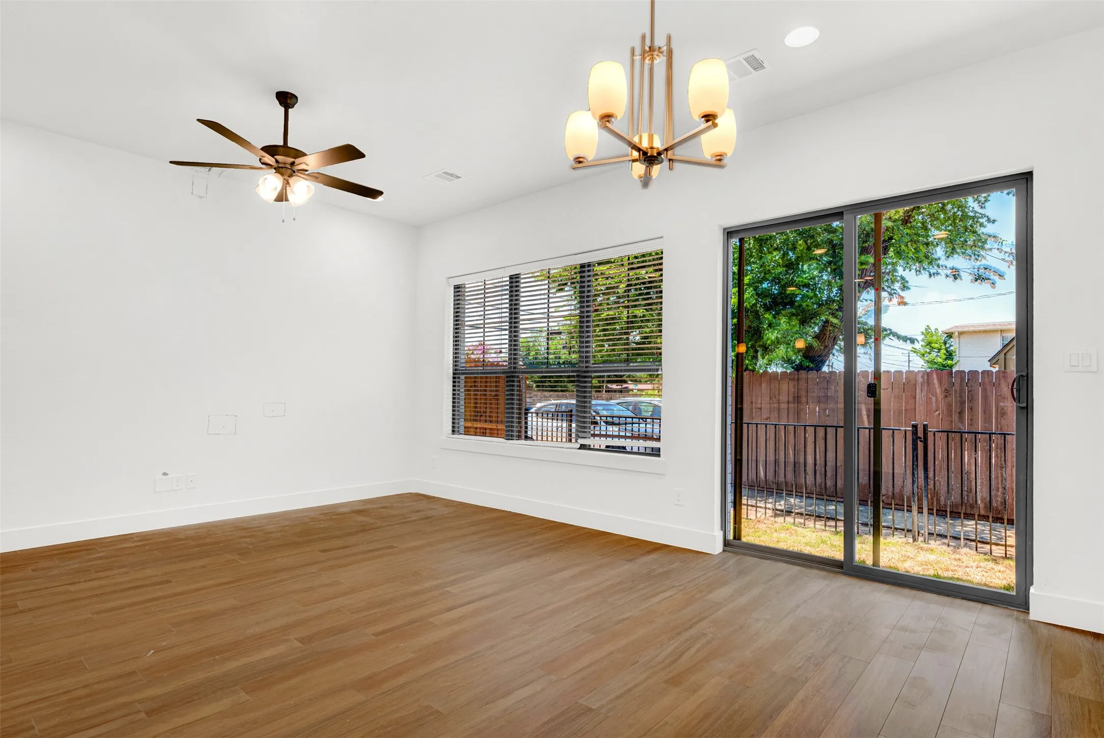 Notice a custom five-bulb light fixture, strategically positioned above the open dining area, which is adjacent to the TV and living area. The private, floor-to-ceiling window treatments (not shown) cover the patio doors.