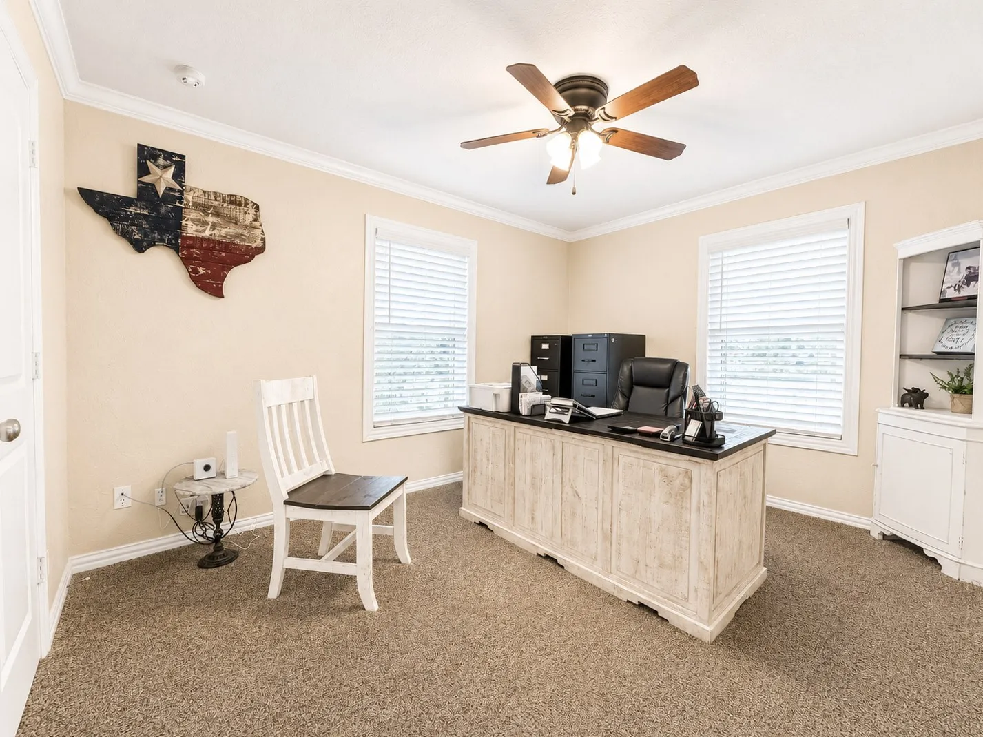 Bedroom or office. Bright room featuring two windows with blinds, a ceiling fan with light fixture, neutral-toned carpeting, and crown molding