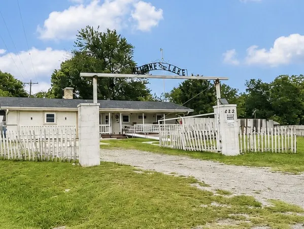 Ranch-style residence featuring a white picket fence and a gravel driveway