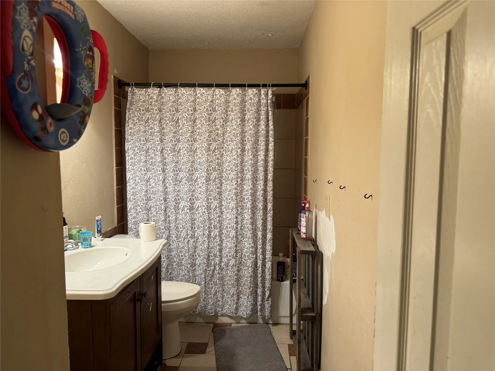 Bathroom featuring a white vanity with an integrated sink, a dark wood-finish cabinet base, and a toilet