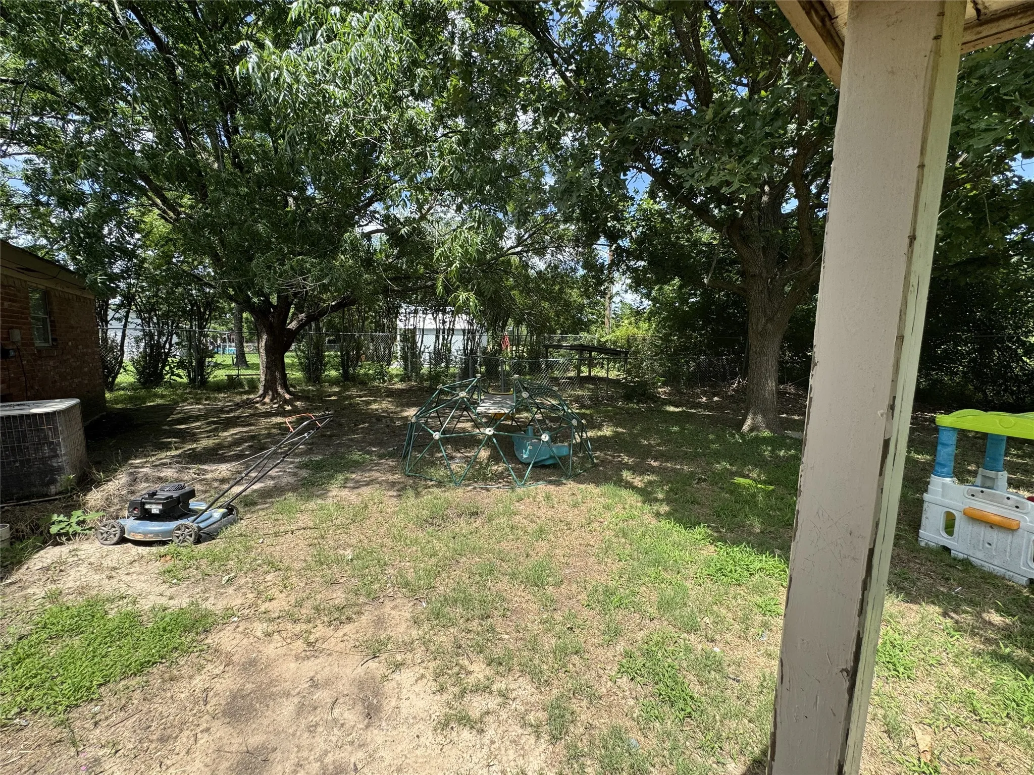 Spacious backyard with mature shade trees, offering ample outdoor area