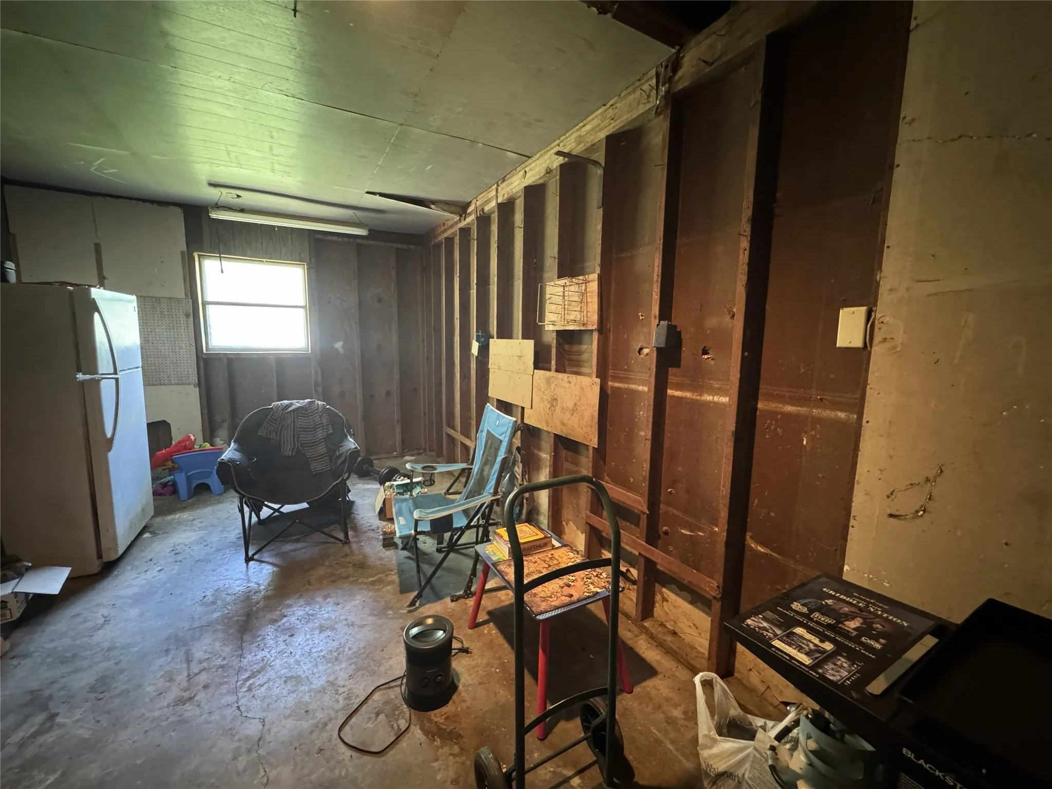 Room featuring exposed wall studs and unfinished paneling