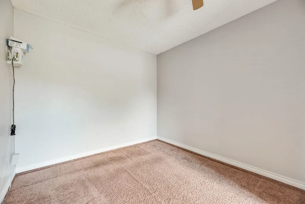 Neutral-toned walls complement the textured carpet flooring
