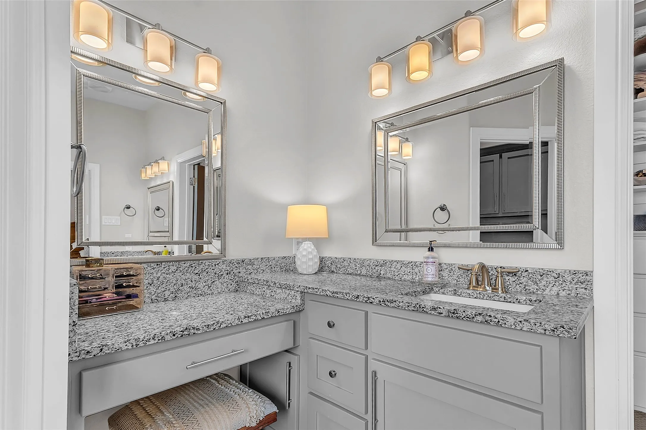 Primary Bathroom Dual vanity area featuring granite countertops, framed mirrors and decorative lighting