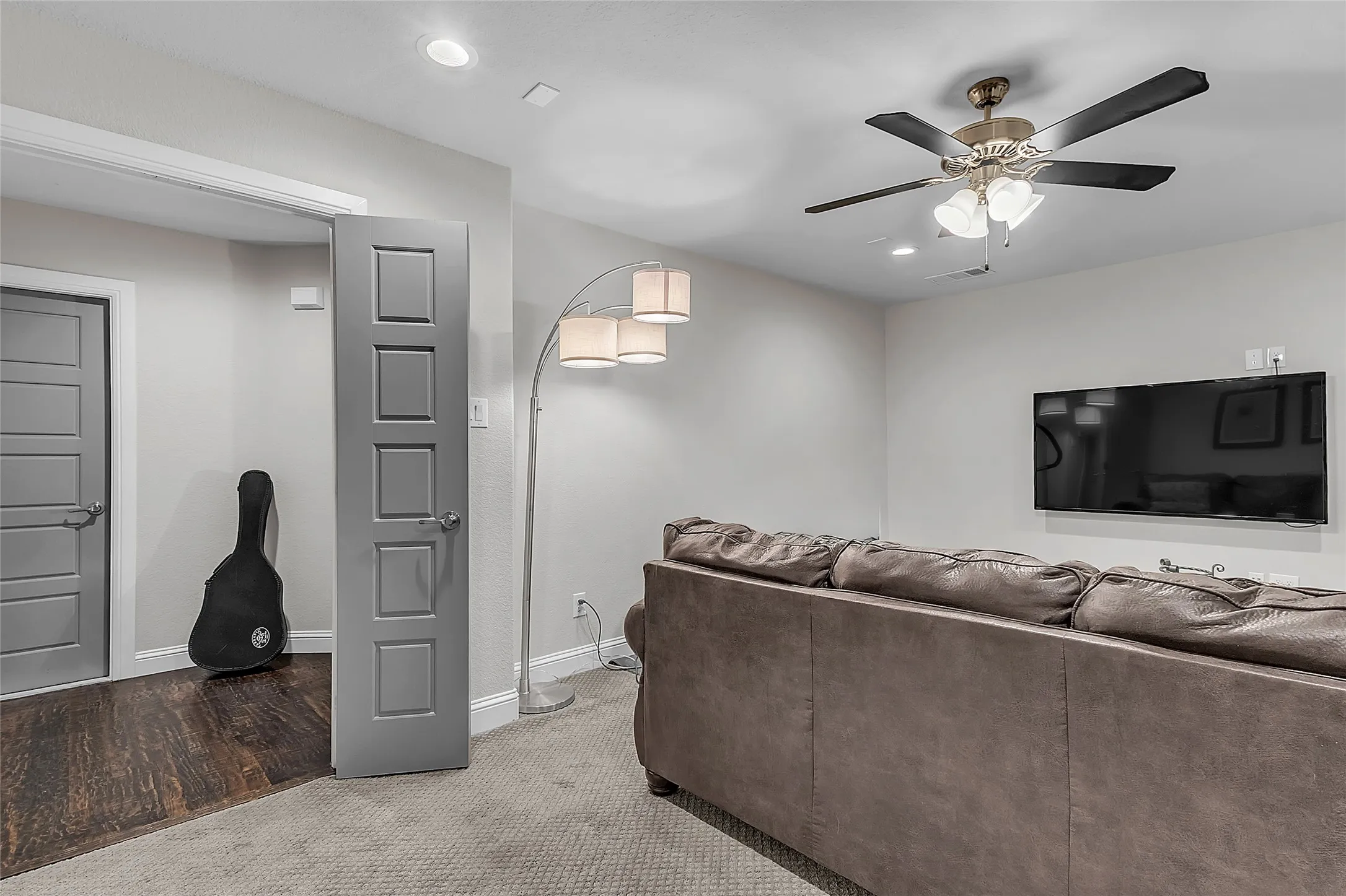 Upstairs bonus room wired for surround sound featuring recessed lighting, ceiling fan, paneled doors, carpet, neutral paint and walk-in access to attic with subfloor. Could easily be a guest quarters, media or game room.