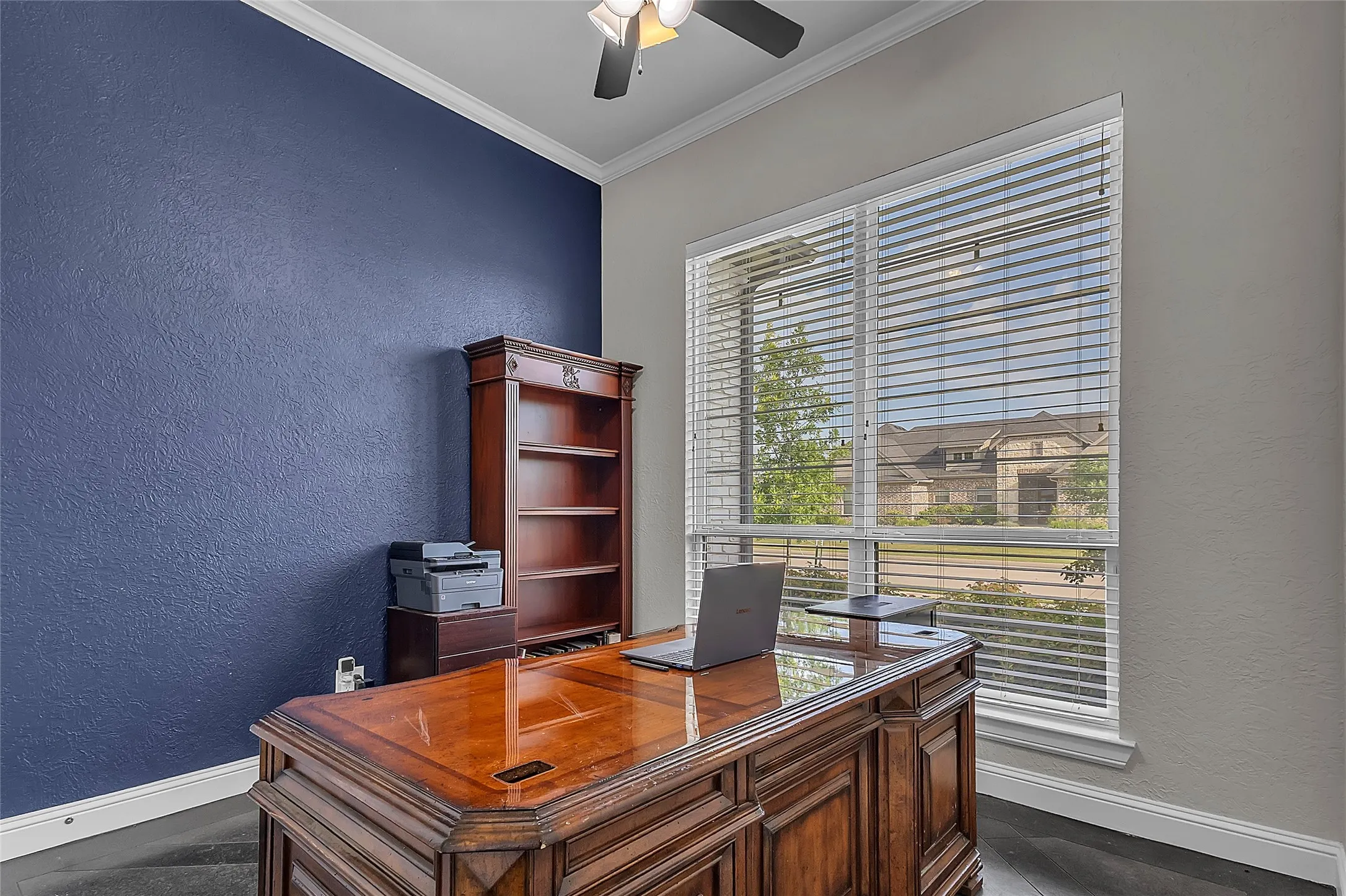 Dedicated office space just off the entry featuring a generous-sized closet, custom concrete-stamped flooring, crown molding, ceiling fan, dark hand-scraped wood flooring and window looking out to the street. (Could easily be an additional bedroom.)