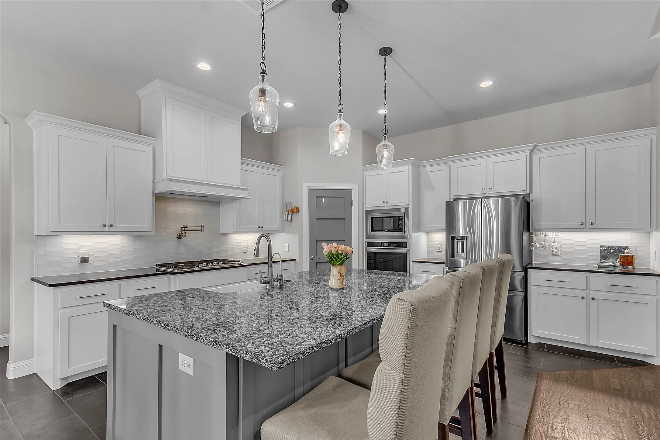 Kitchen featuring a large island with granite countertop, shaker-style cabinetry, stainless steel appliances, a gas range with pot filler, and recessed lighting