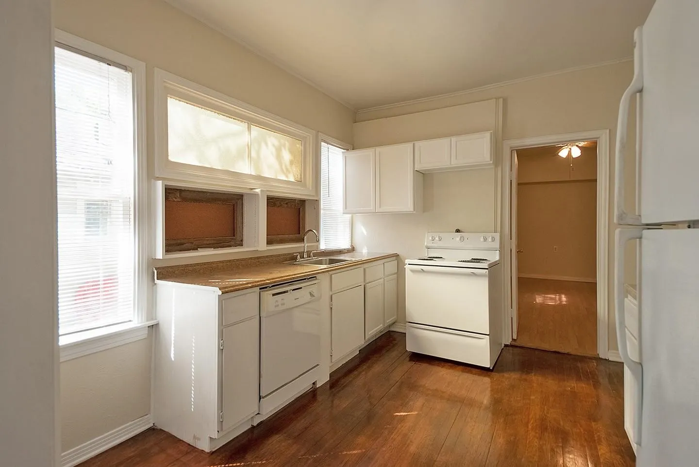 A cozy kitchen with white cabinets, a dishwasher and a stove, creating a clean and inviting cooking space.
