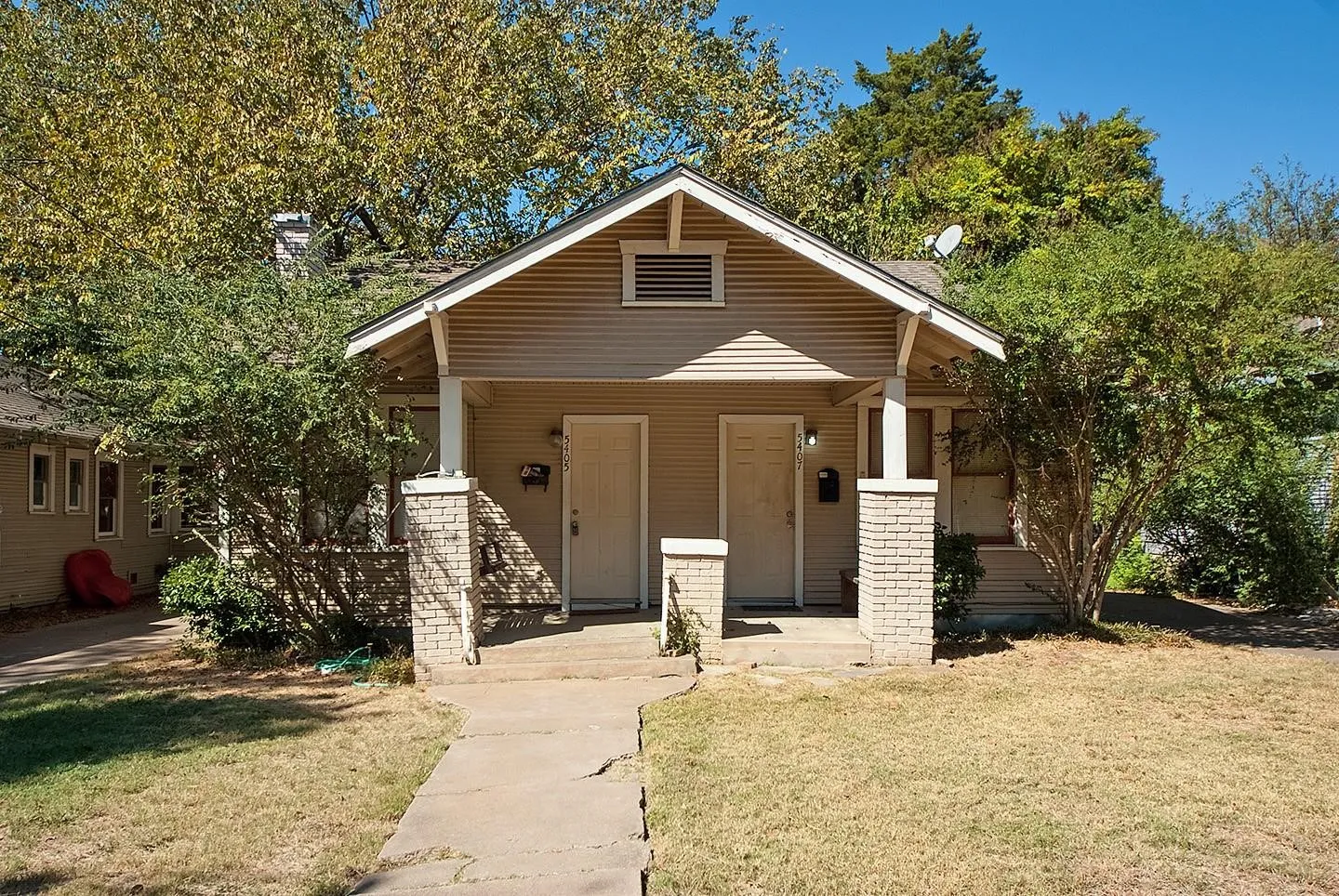A cozy house with a charming front porch and a well-kept yard, creating a warm and inviting atmosphere.