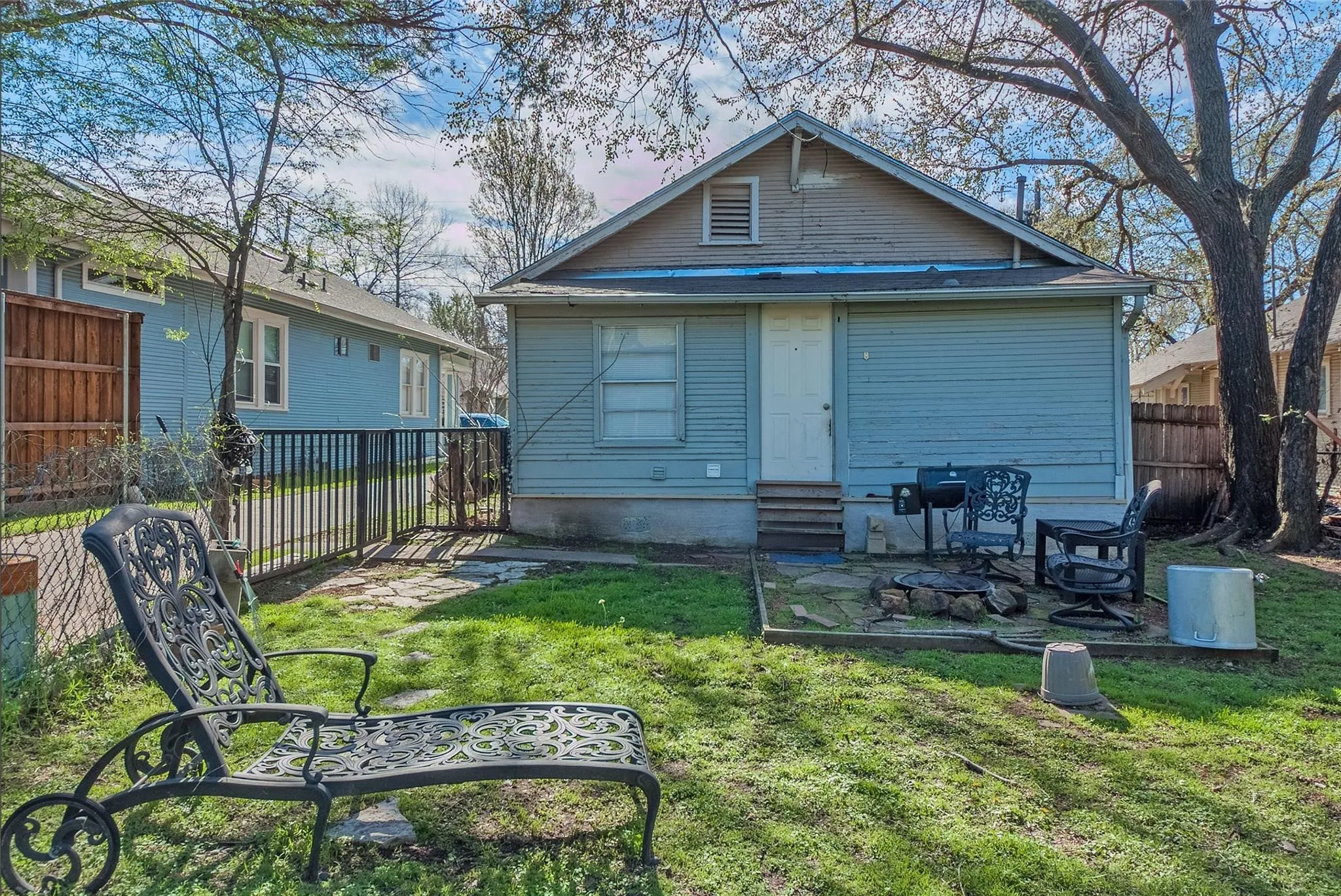 A cozy backyard with a patio area and a grill, perfect for outdoor cooking and relaxation.