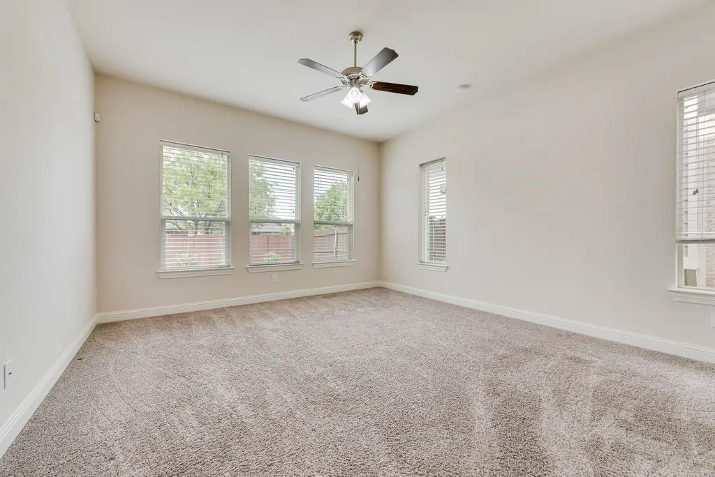 Carpeted room featuring a vaulted ceiling and a ceiling fan
