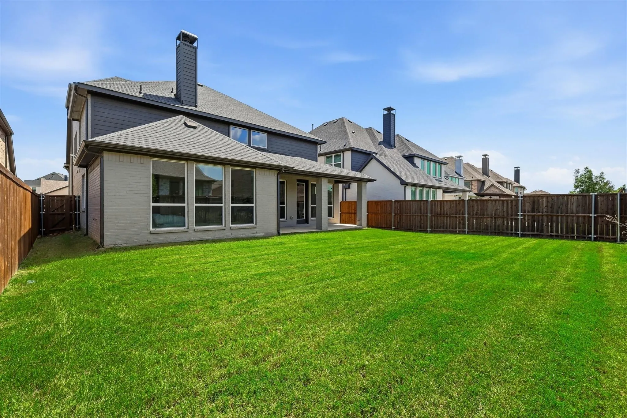 Expansive green lawn with a privacy fence