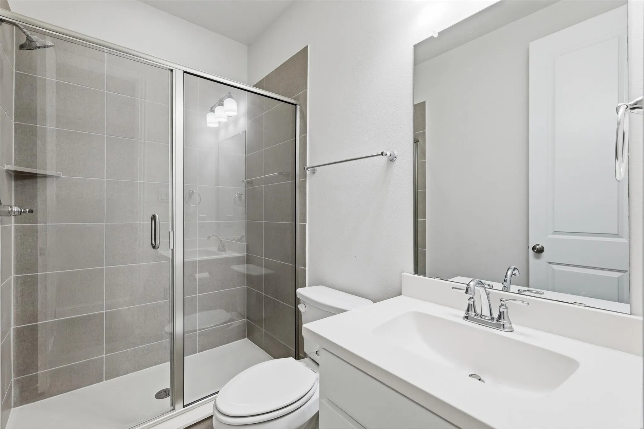 Bathroom featuring a vanity with an integrated sink, a large wall-mounted mirror, and chrome fixtures