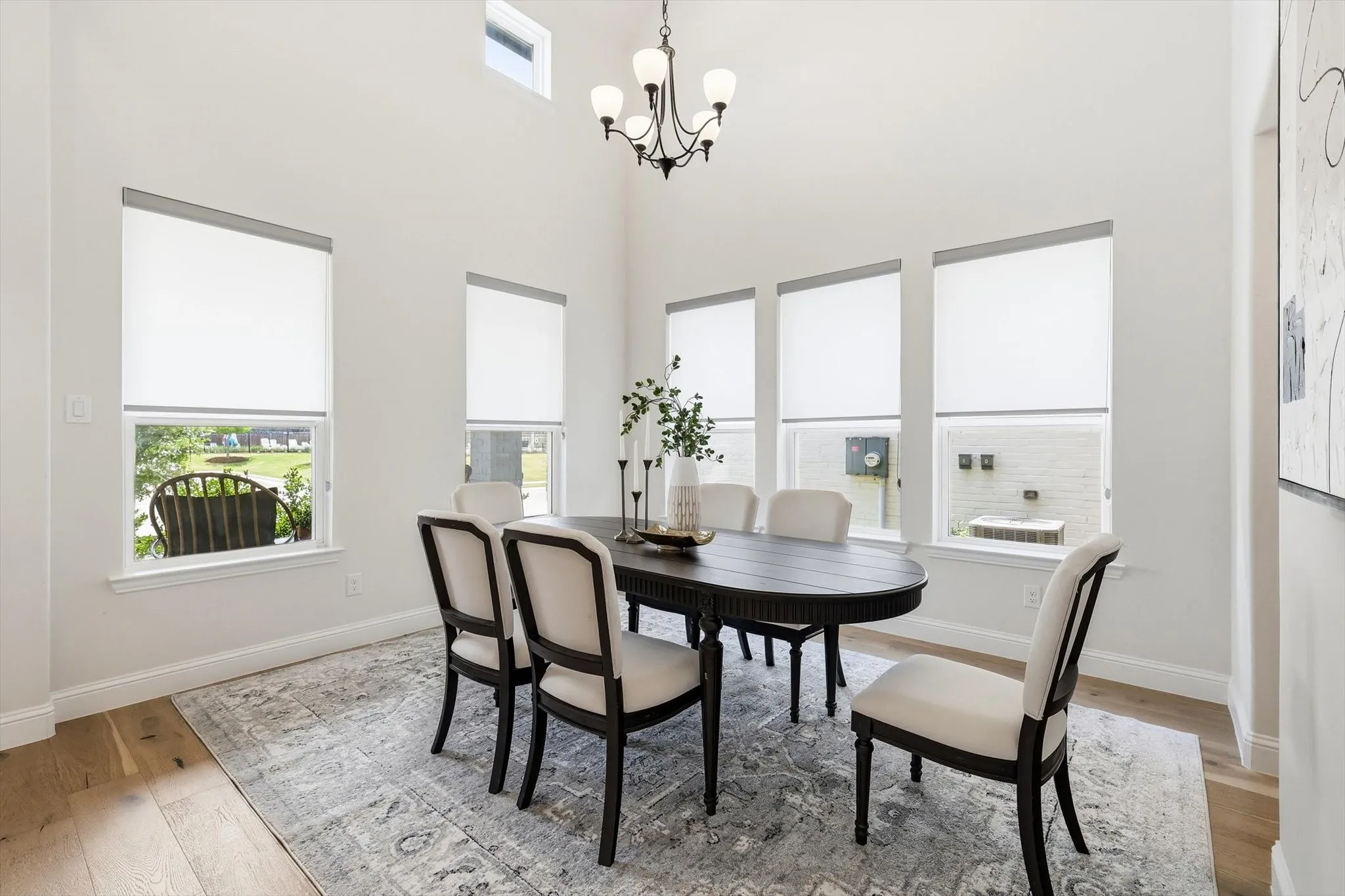 Dining area featuring vaulted ceilings, wood-finish flooring, and multiple windows