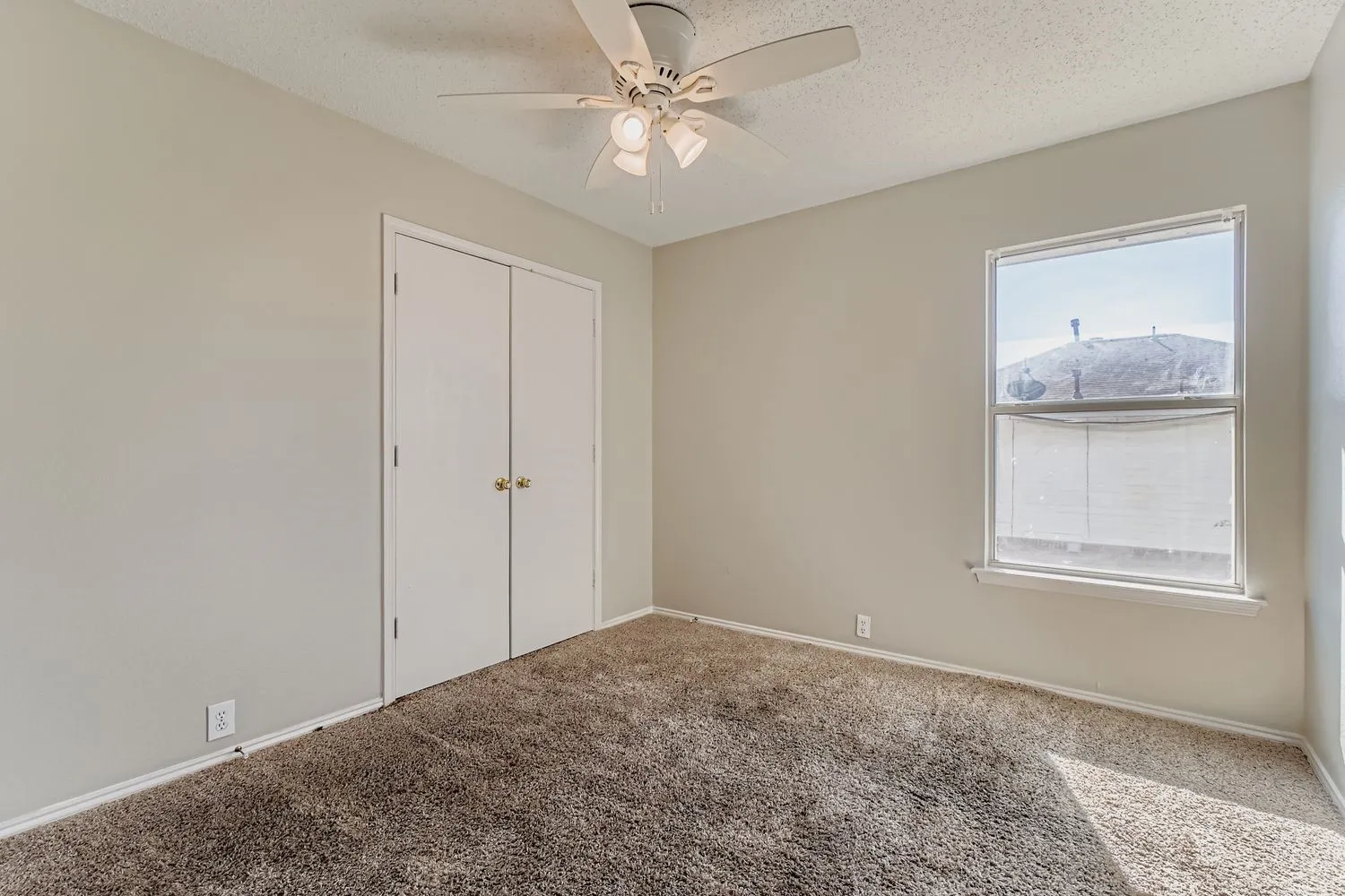 Carpeted room with neutral wall paint and a textured ceiling