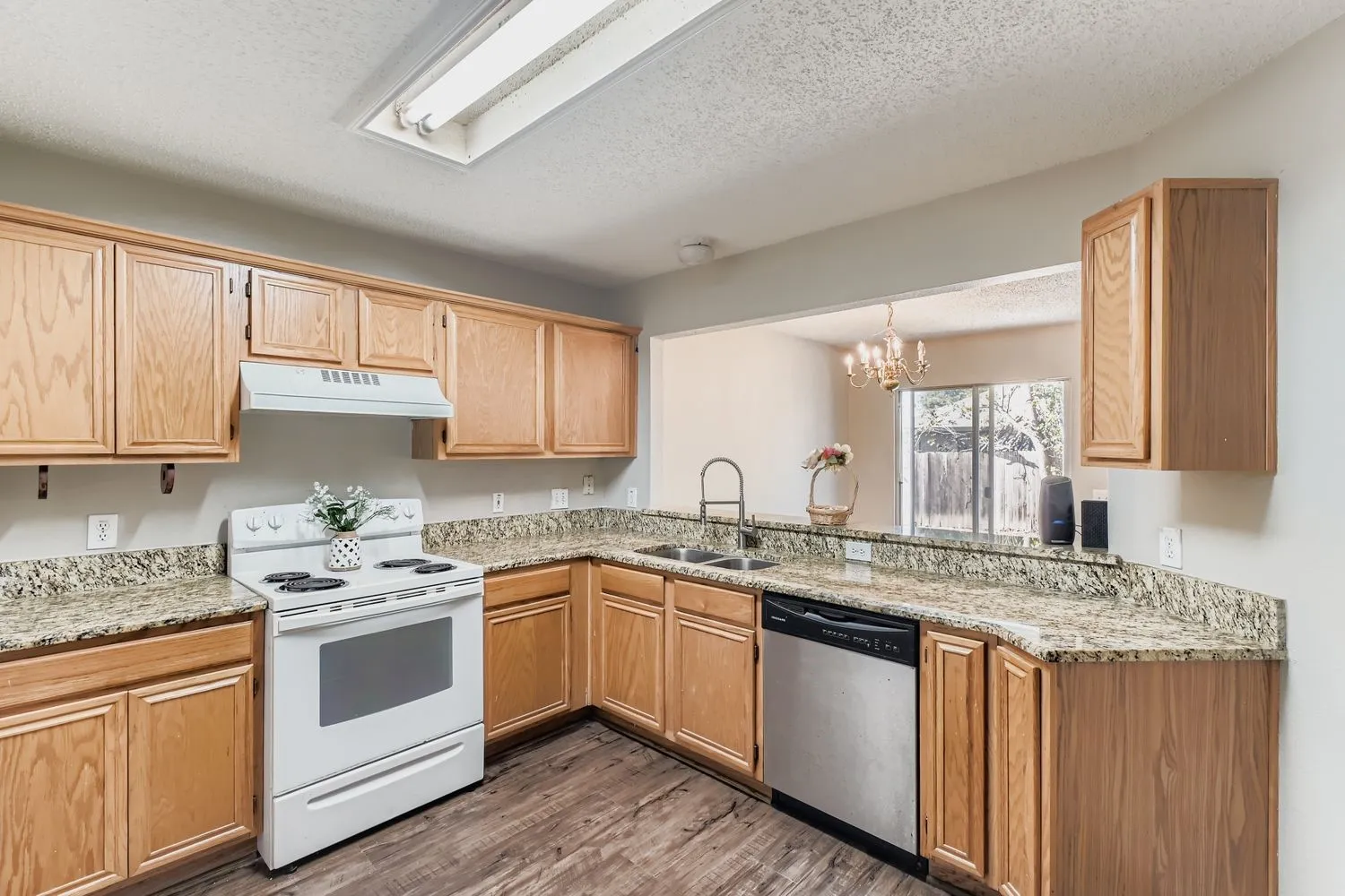 Well-appointed kitchen featuring wood-finish cabinetry, a white electric range, and a stainless steel dishwasher