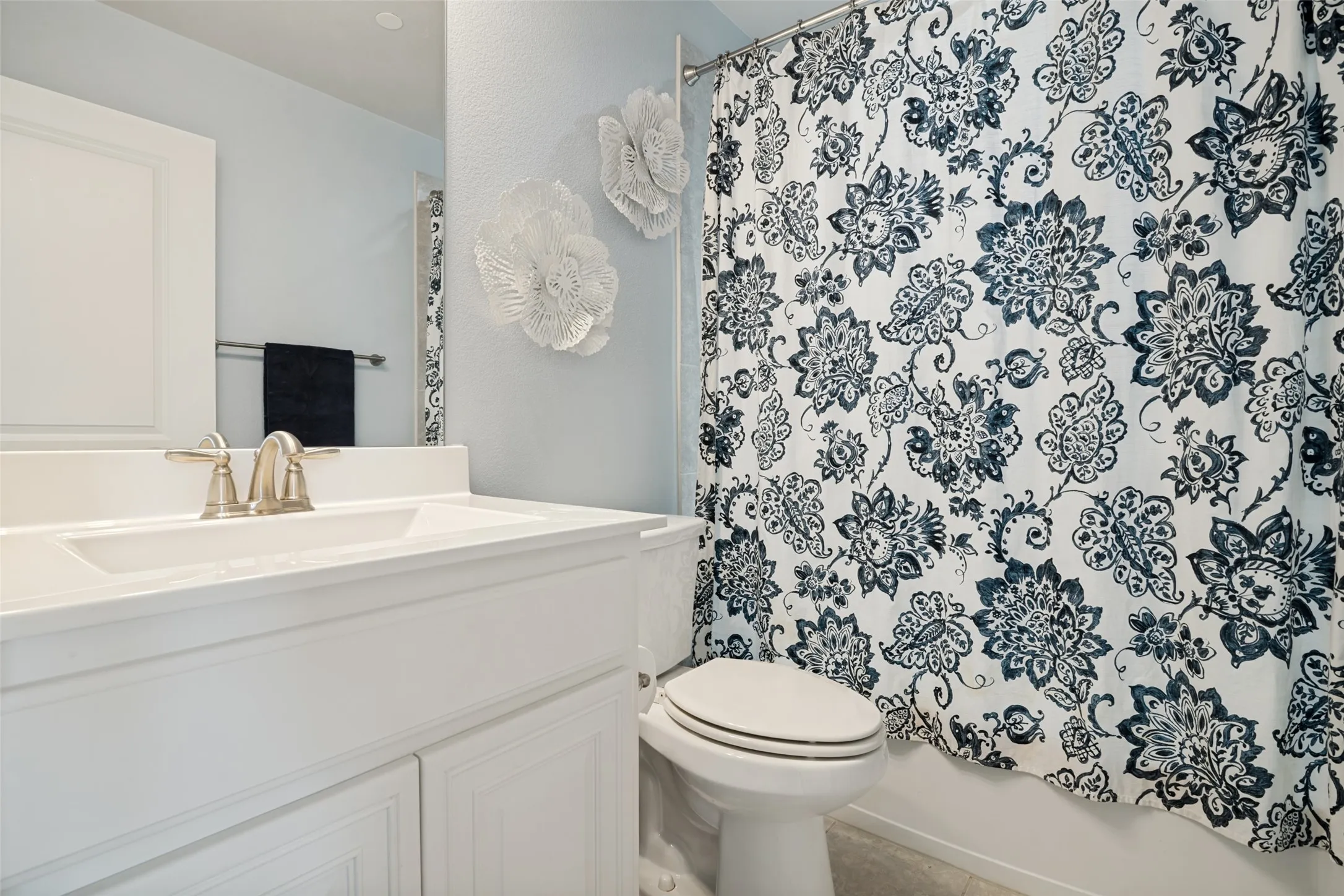 Bathroom featuring a white vanity with an integrated sink, brushed nickel faucet, and a large mirror