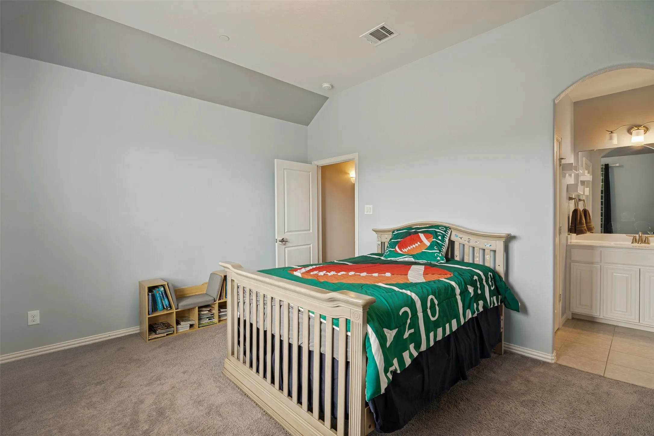 Spacious room featuring vaulted ceilings, light gray wall paint, and plush carpet flooring