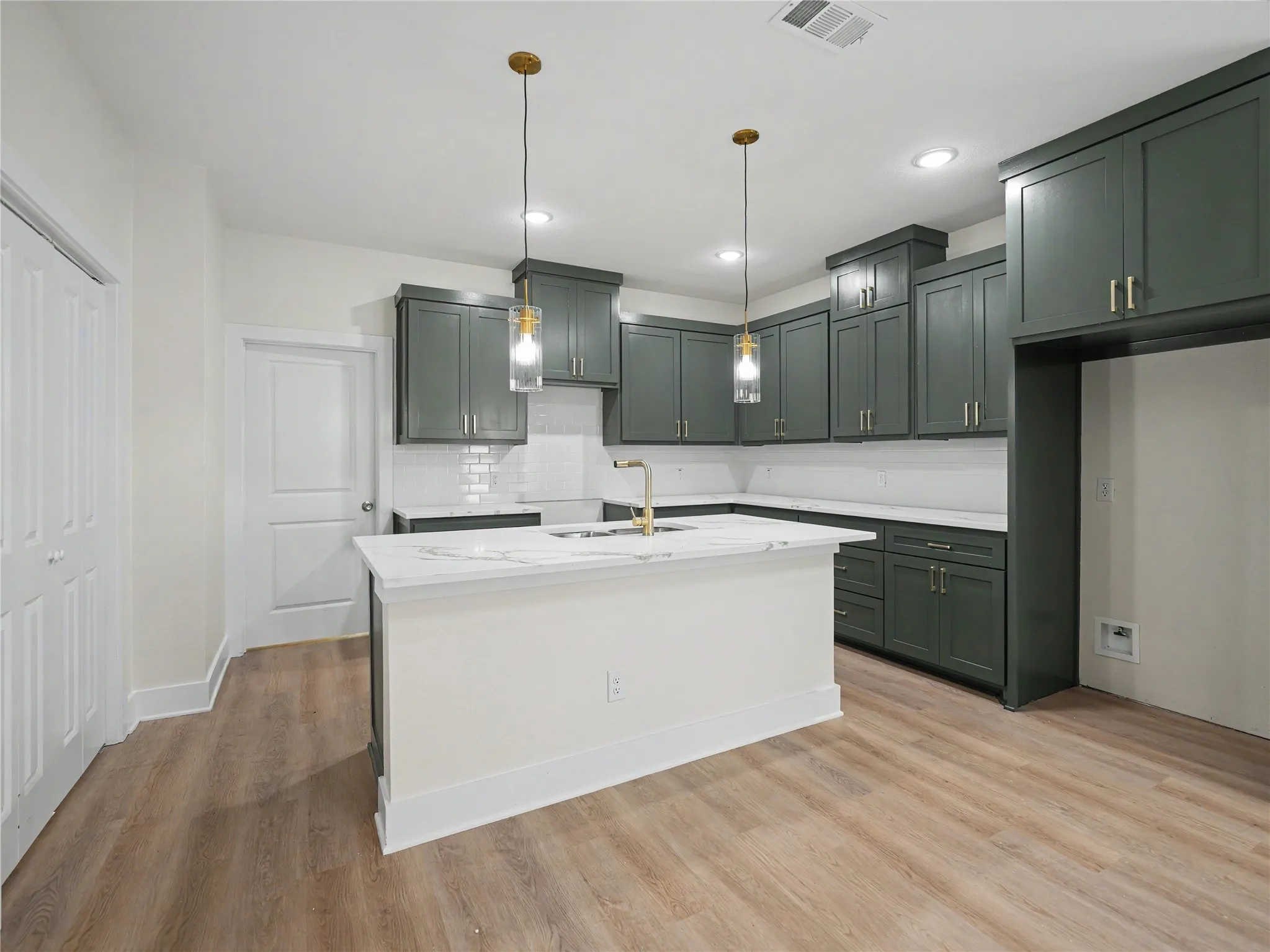 Kitchen featuring a central island, dark green cabinetry, white subway tile backsplash, recessed lighting, and wood-finish flooring