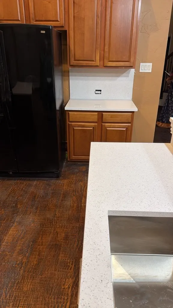 Wood-finish flooring, light-toned countertops, and wood cabinetry