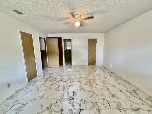 Spacious room featuring large format tile flooring with a white and gray marble-look pattern