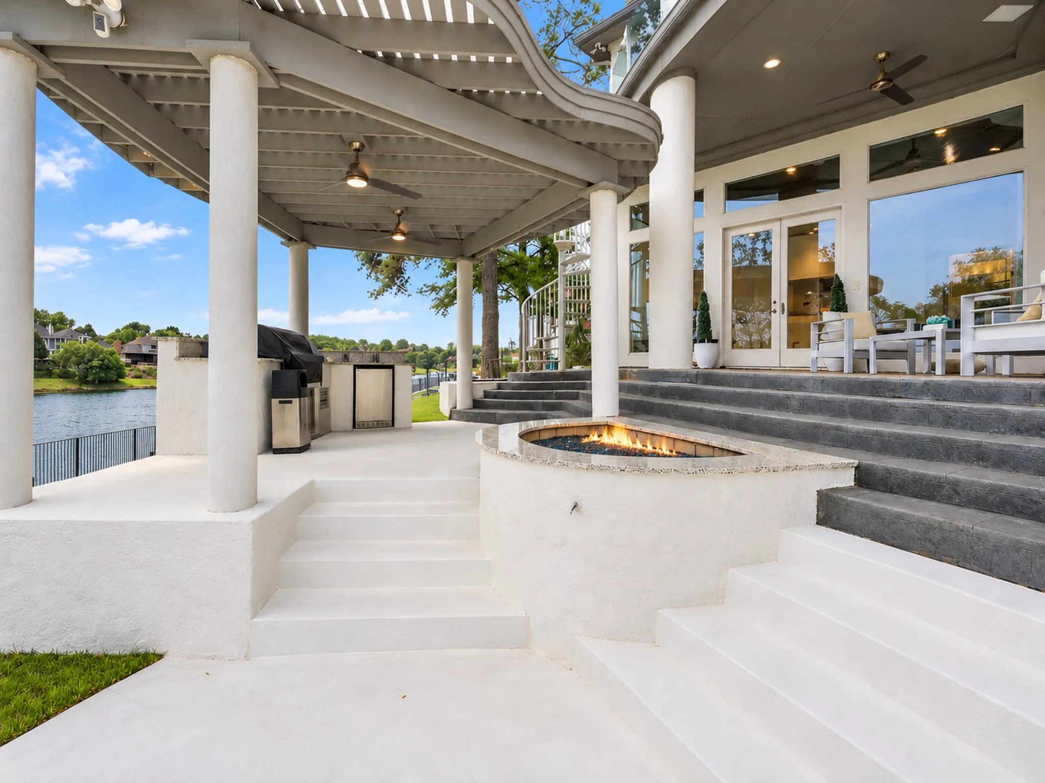 Imagine evenings by the fire pit, grilling in your professional outdoor kitchen, all under a covered deck with serene water views. A private staircase leads directly to your primary suite balcony-seamlessly blending relaxation and luxury.