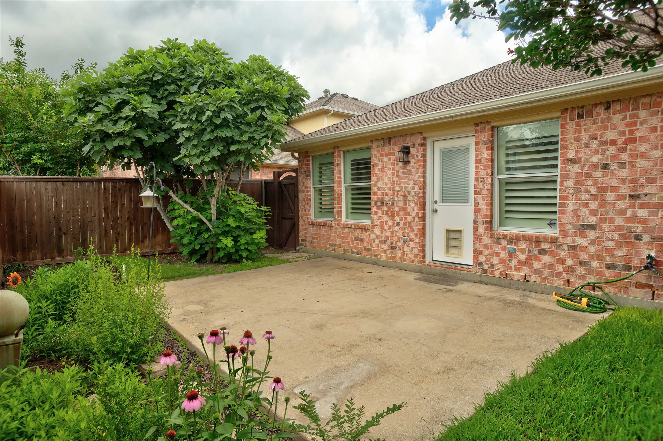 Nice enclosed patio space with new sod and pretty landscaping