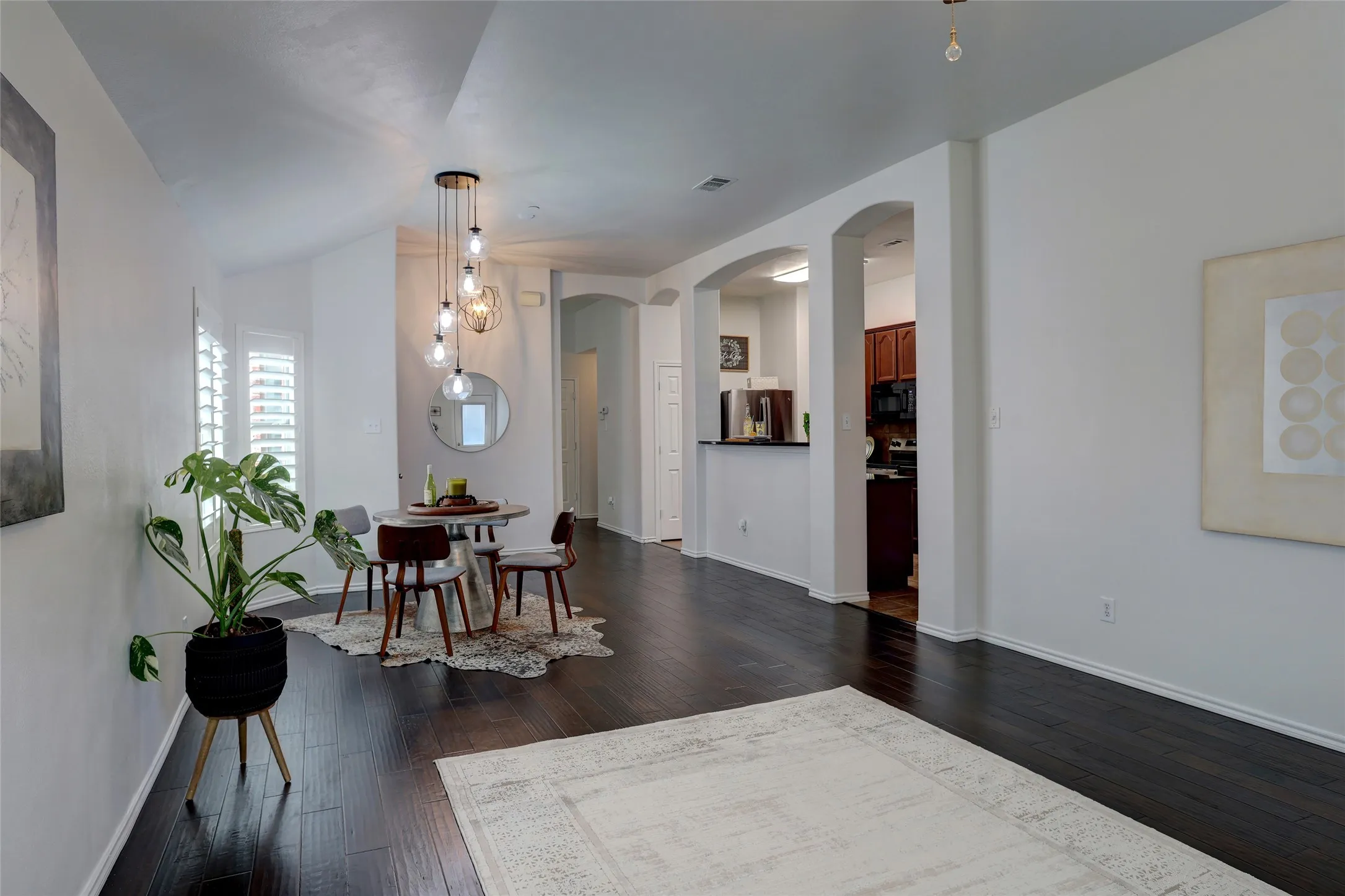 Dining area adjacent living room with new modern light fixture